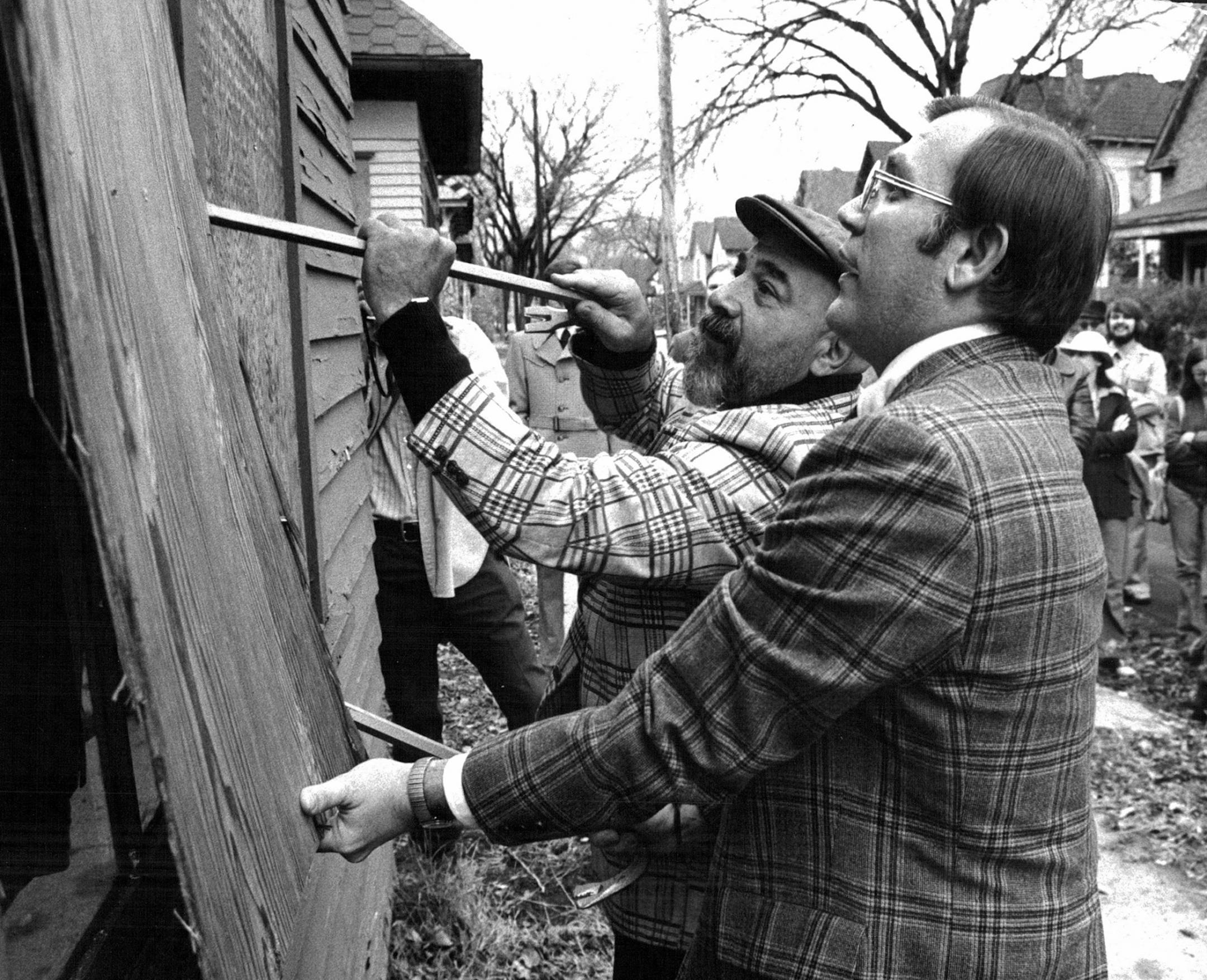 October 25, 1975 Boards come off Milwaukee Av. house for rehabilitation -- Mayor Albert Hofstede pulled off the boards as Ninth ward Alderman Zollie Green manned the crowbar during a ceremony unboarding the windows and doors of a vacant house at 2009 Milwaukee Av. Friday. The house is the first of five to be rehabilitated by the Greater Minneapolis Metropolitan Housing Corp. and the Milwaukee Avenue Community Corp. A residents group, the Seward West Project Area Committee, has been working for f