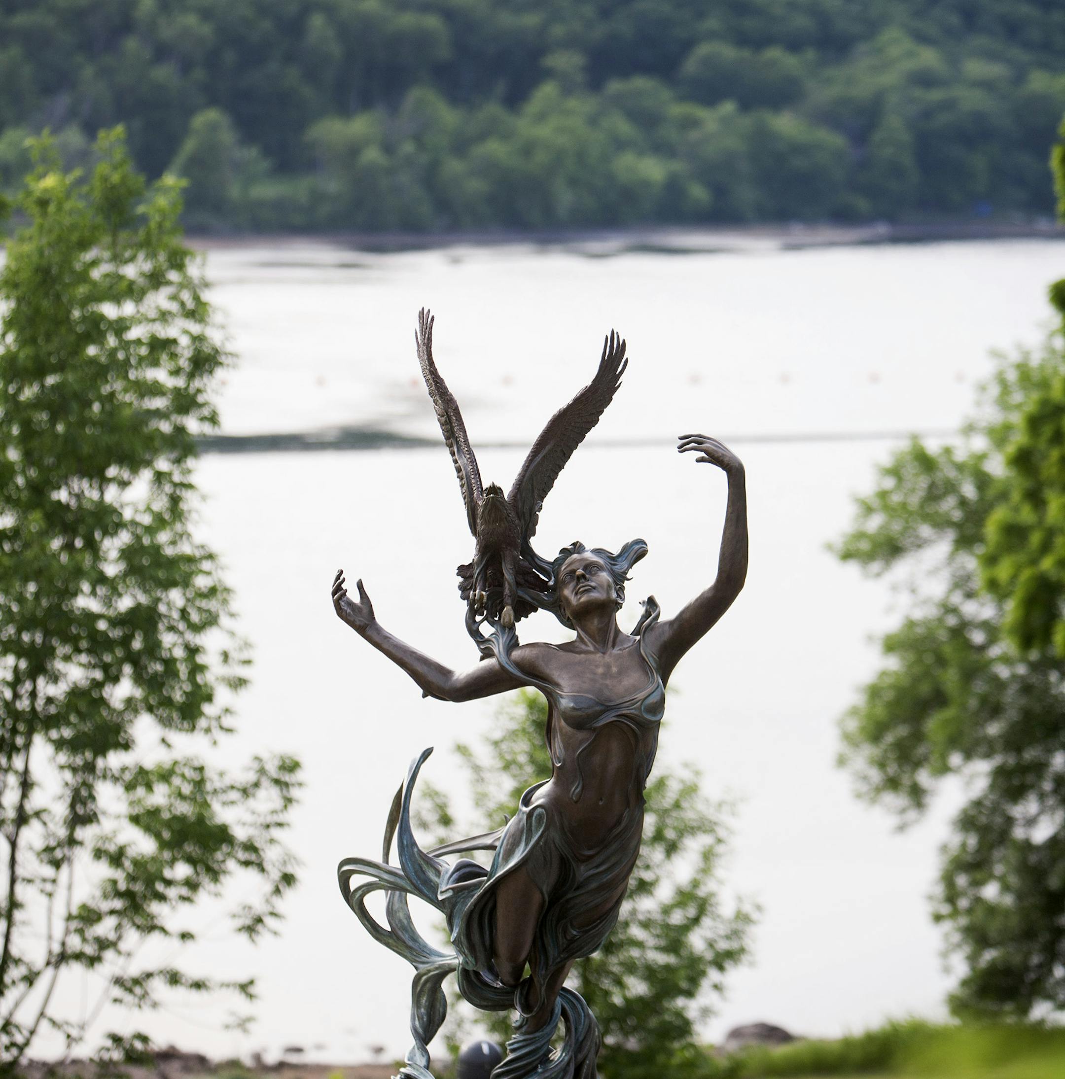 River Spirit, a 2007 bronze sculpture by Julie Ann Stage, rises above the water, standing on shore at the St. Croix Falls overlook in Wisconsin June 26, 2014. On the opposite side of the St. Croix River lies Taylors Falls, Minnesota. (Courtney Perry/Special to the Star Tribune)