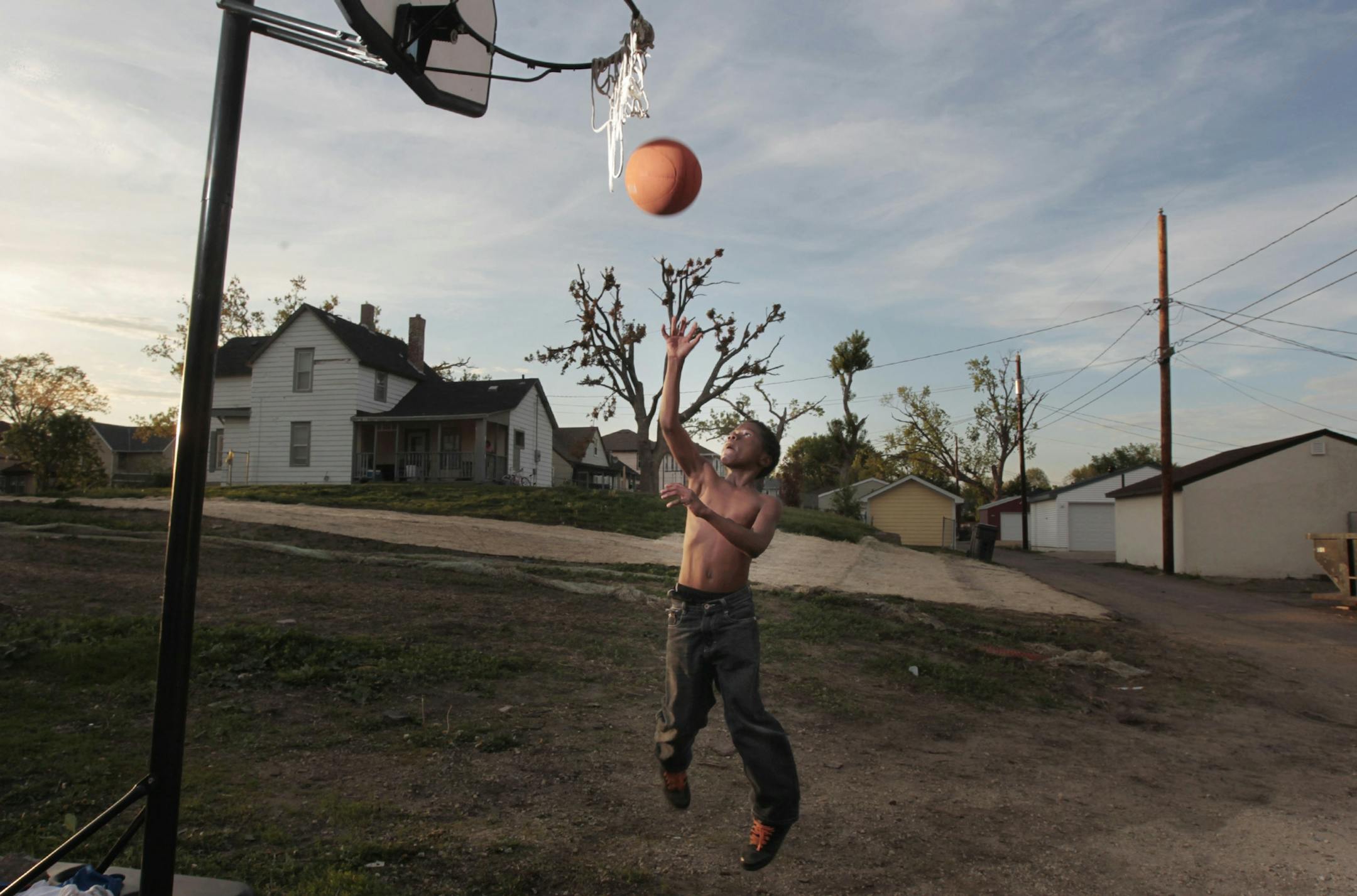Derek Leake 11, played basket ball in the alley behind his family home in the 3000 block of Logan Avenue north. Last May 22, 2011 a tornado struck north Minneapolis clearing out many lots.