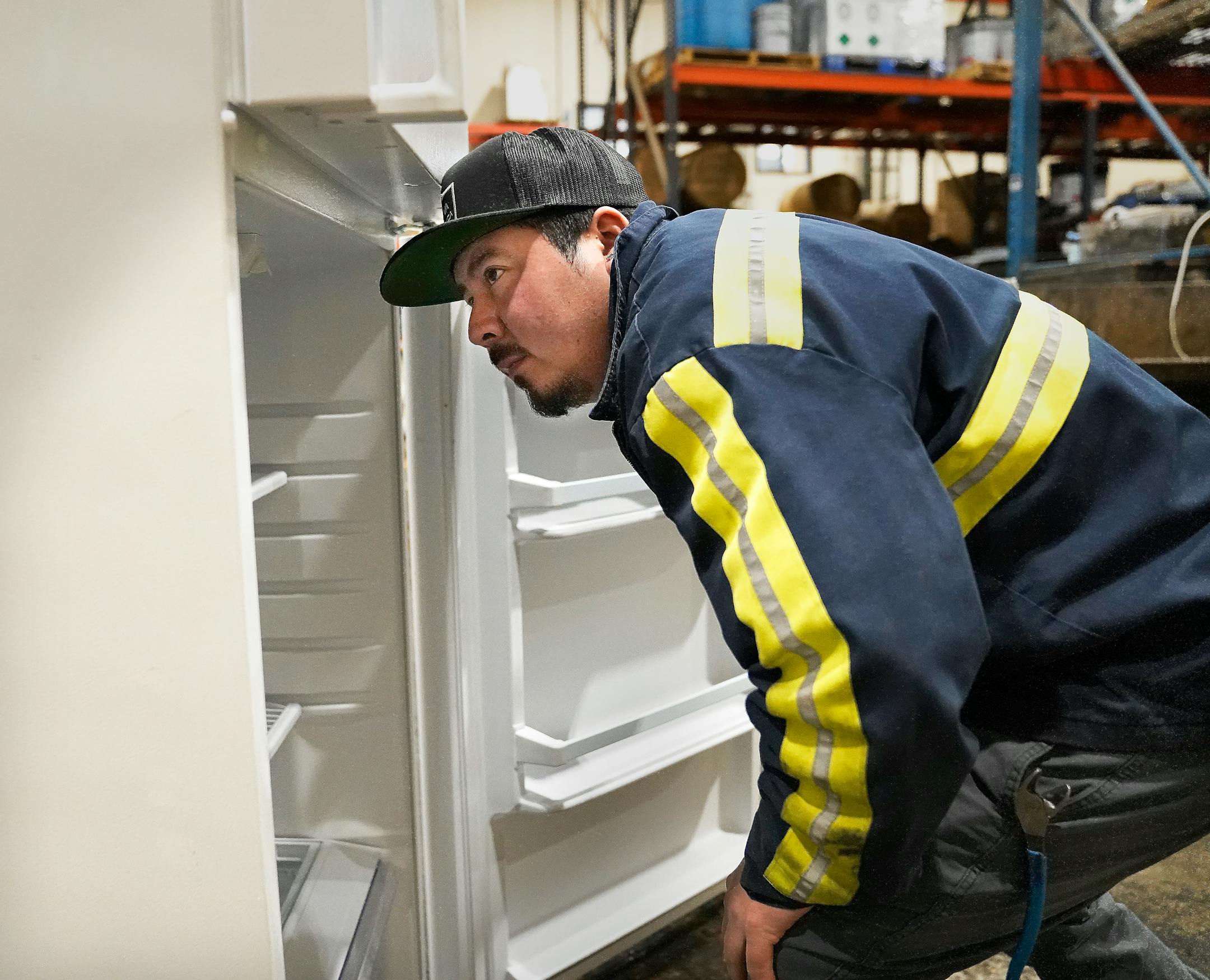 J.R.'s Advanced Recyclers dock supervisor Erick Perez looks over an old refrigerator for recycling.