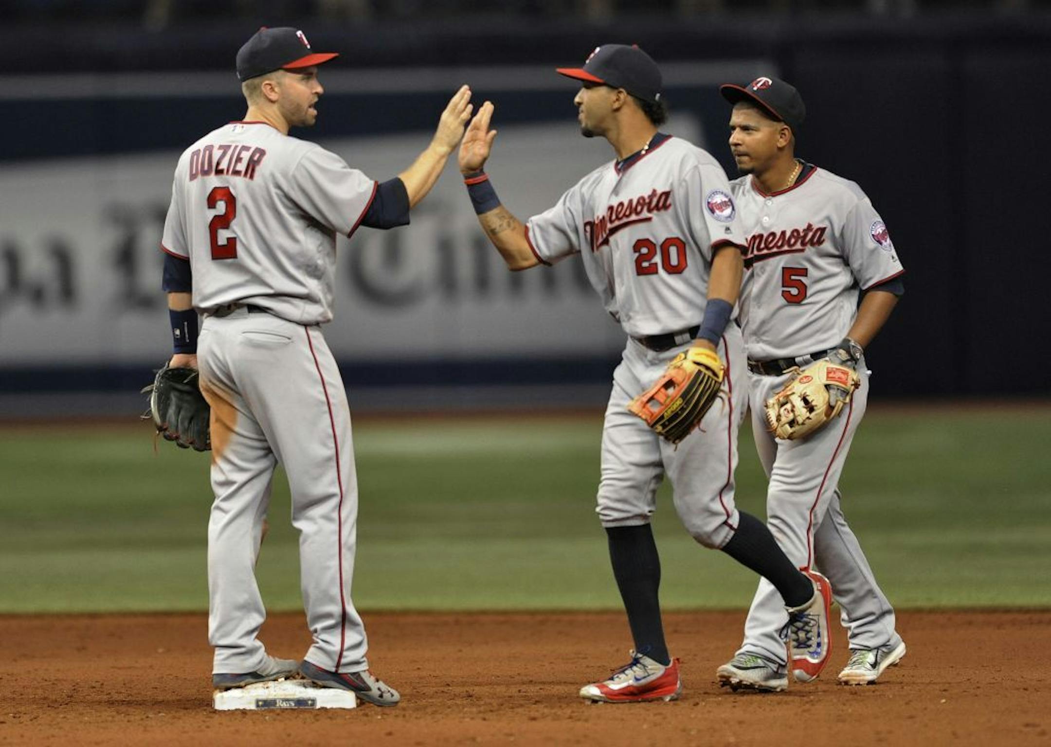 Minnesota Twins' Brian Dozier, left to right, Eddie Rosario and Jorge Polanco celebrate a 6-2 win over the Tampa Bay Rays during a baseball game Friday, Aug. 5, 2016, in St. Petersburg, Fla.