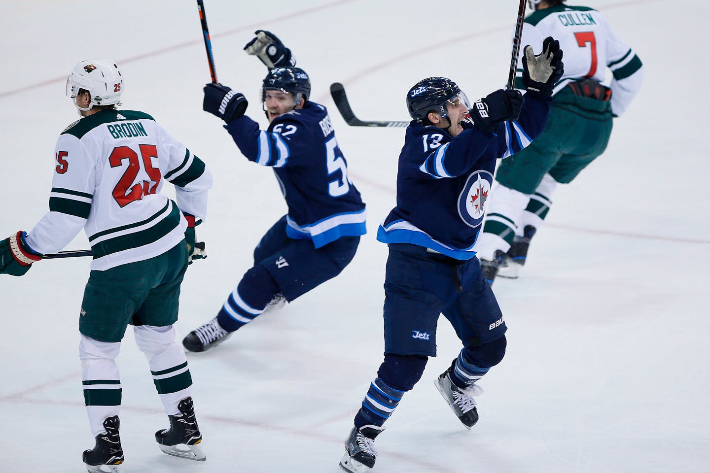 Winnipeg Jets' Jack Roslovic (52) and Brandon Tanev (13) celebrate Tanev's goal, as the Wild's Jonas Brodin (25) and Matt Cullen (7) turn away during the first period in Game 5.