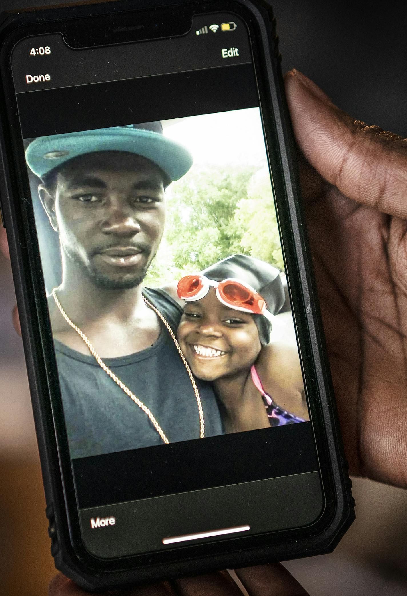 Delois Stewart-McGee held a cellphone photo of her brother Oscar Stewart and one of his daughters.