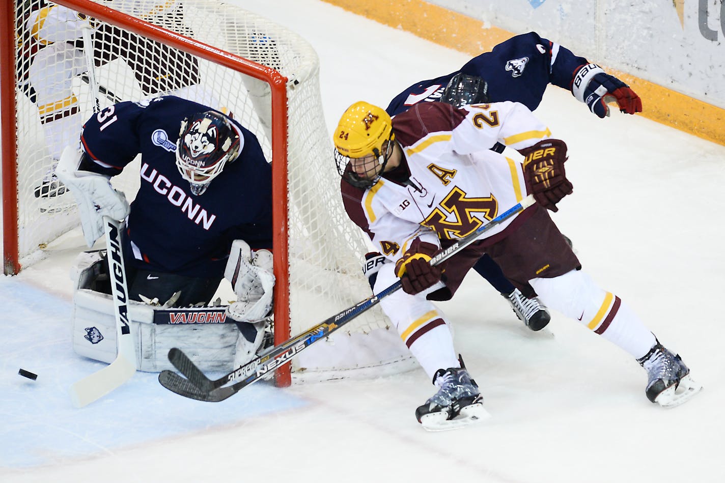 Gophers right wing Hudson Fasching (24) is unable to score off the wrap around on Connecticut goalie Rob Nichols.