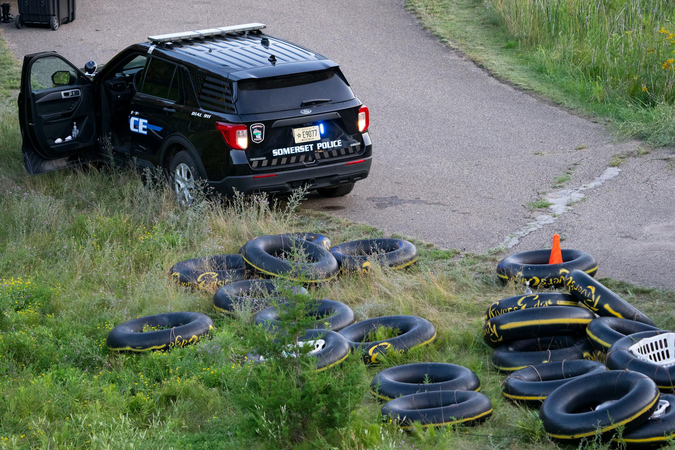 Tubes sit on the bank of the Apple River while Water Recovery authorities comb the area with metal detectors after five people were stabbed while tubing down the river Saturday, July 30, 2022 in Somerset, WI.   ]