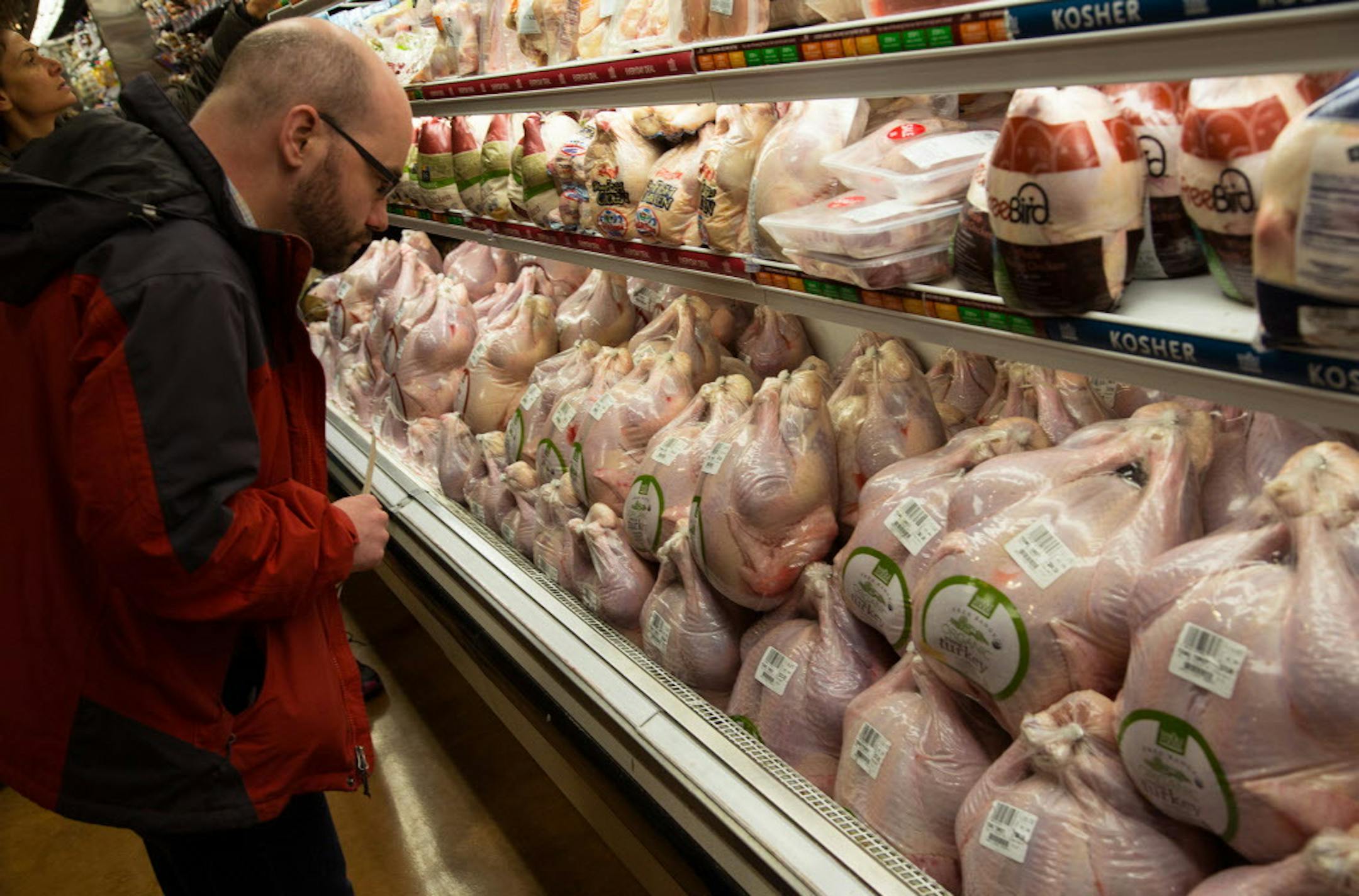 Shoppers compare turkeys at a Whole Foods Market in the Manhattan borough of New York, Nov. 21, 2013. The gourmet market sector's leading chain faces growing competition, making this season one of the best ever for shoppers planning a Thanksgiving meal. (Uli Seit/The New York Times)