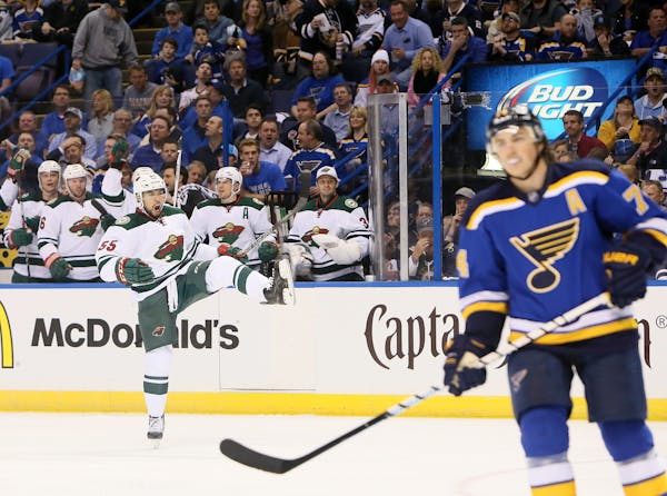 The Minnesota Wild's Matt Dumba, left, reacts after scoring in the second period against the St. Louis Blues and T.J. Oshie, right, during the first r