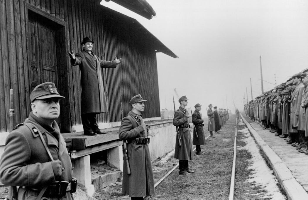 In 'Schindler's List,' German industrialist Oskar Schindler (Liam Neeson, on platform) welcomes his workers to the safety of his new factory at Brinnlitz.