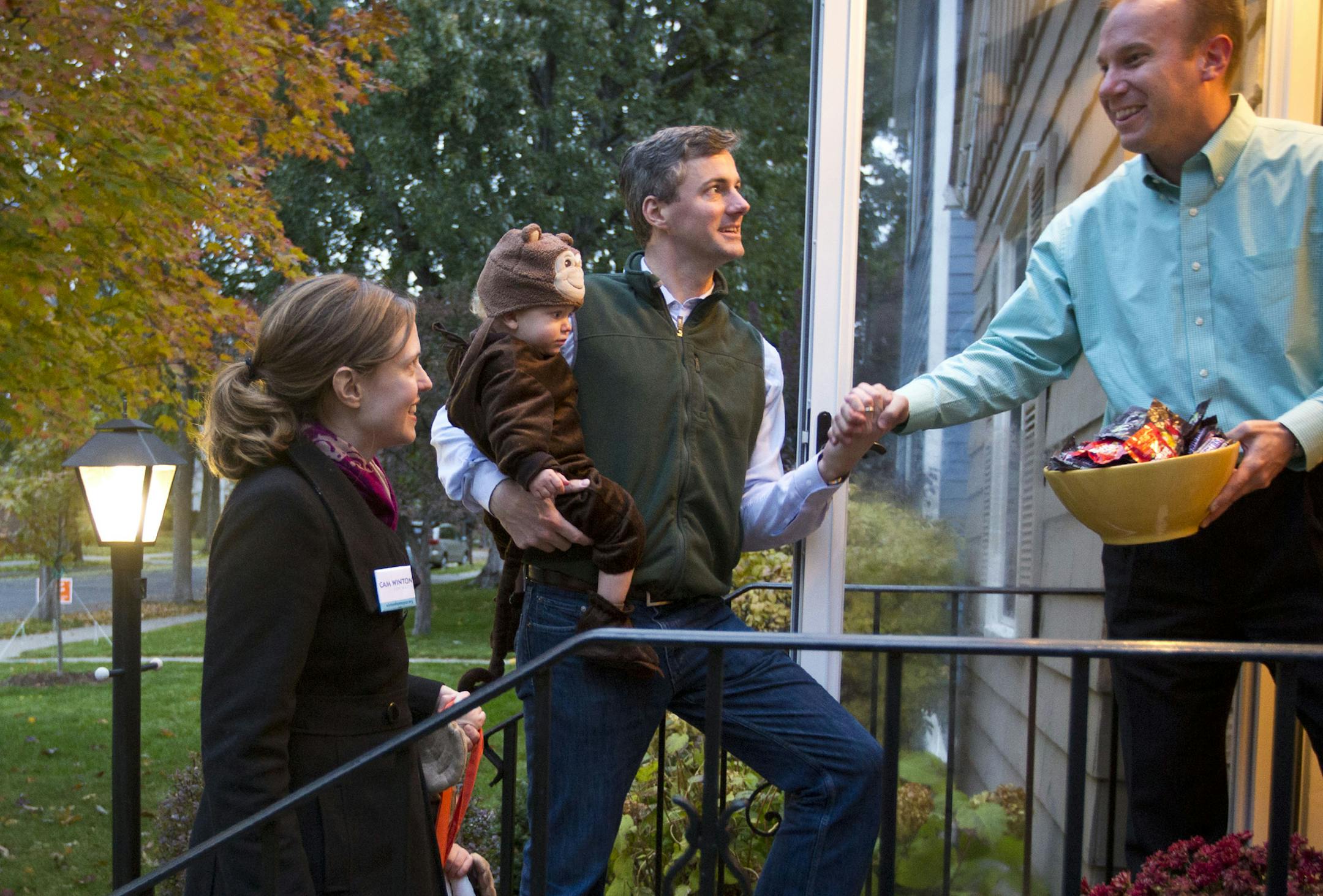 Cam Winton: The independent and his wife, Emily Pryor Winton, took their kids trick-or-treating at the home of a neighbor, Ross Widmoyer, right.