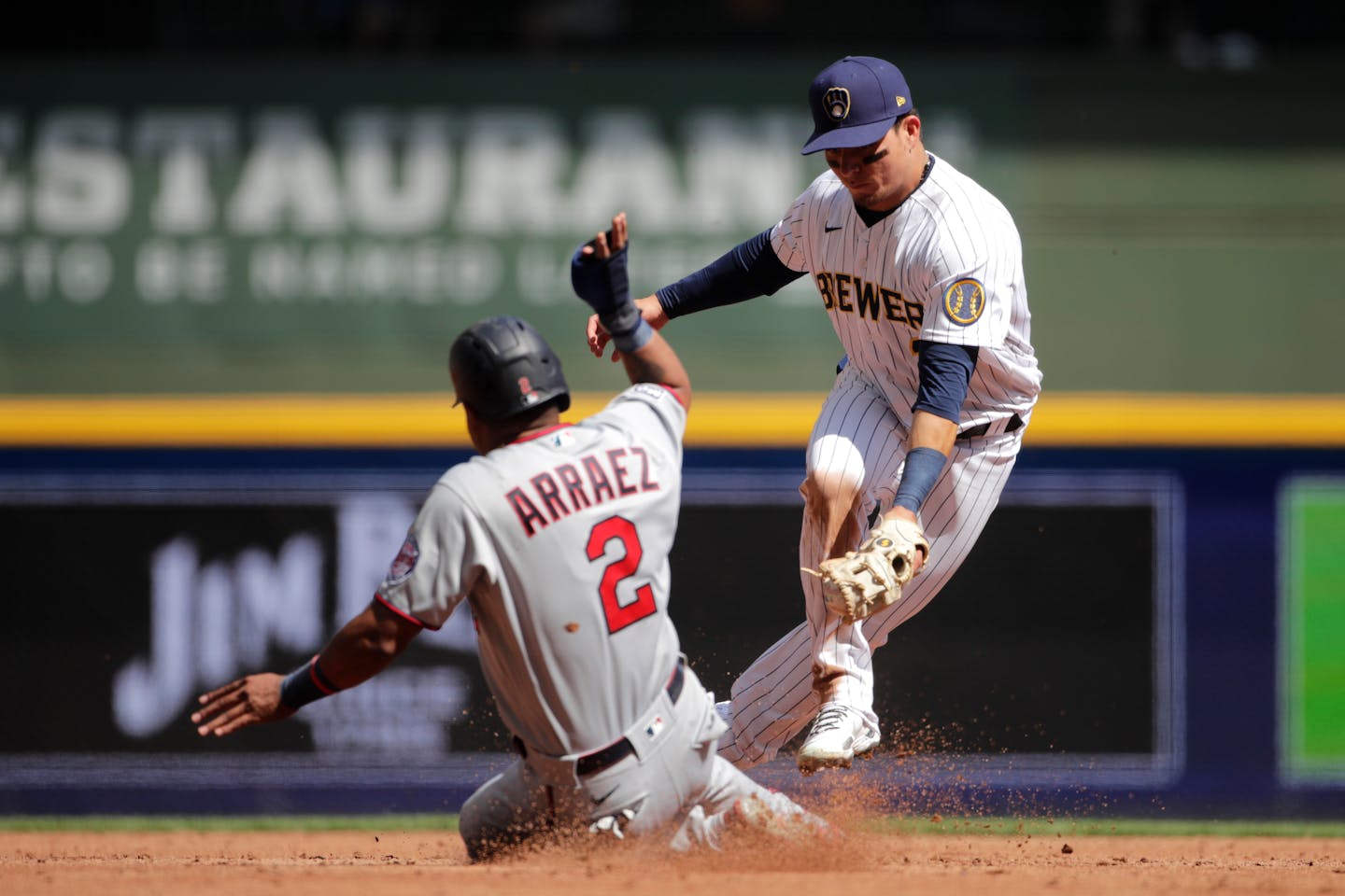 Milwaukee Brewers' Luis Urias, right, tags out Minnesota Twins' Luis Arraez at second during the third inning of a baseball game Sunday, April 4, 2021, in Milwaukee. (AP Photo/Aaron Gash)