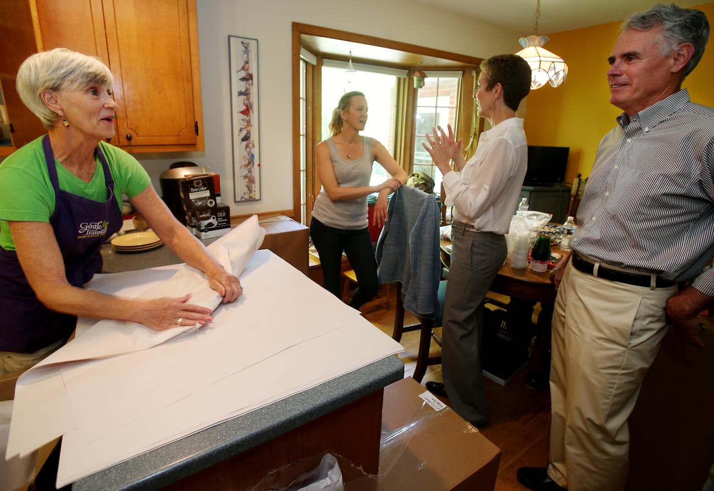 Diane Bjorkman, second from right, co-owner of Gentle Transitions, talked with Shawna Hedlund, daughter of the homeowners, about the move while Diane Saterdalen, left, wrapped dishes as she spoke with company co-owner Bill Lehman.