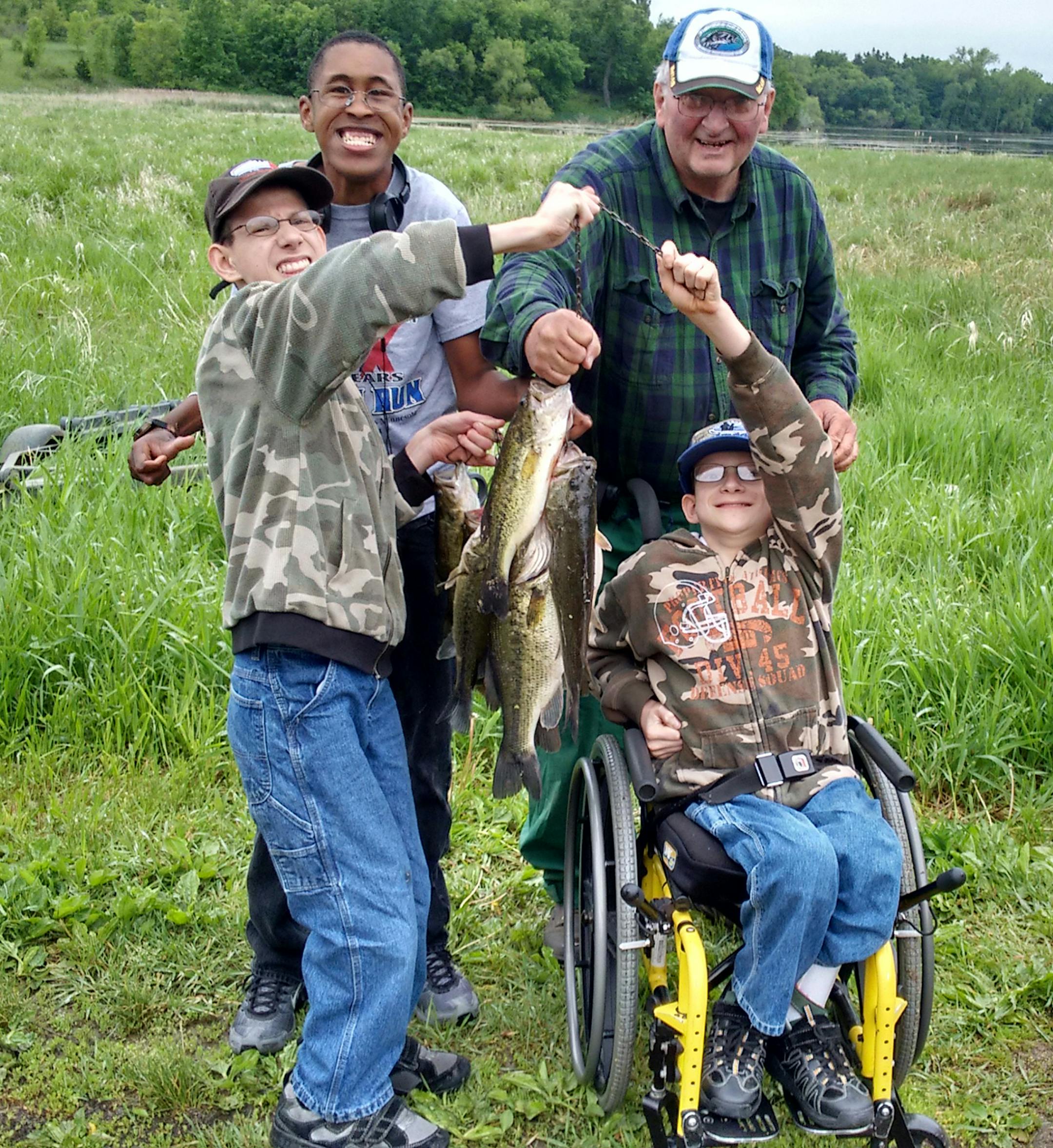 School bus driver Perry Whitney, back right, with three brothers ó and fishing buddies ó he drives to school each day: Justas, left, originally from Lithuania, Omar from Jamaica and Ivan (preferred nickname: Vanya) from Russia. The three boys were adopted by Rick and Kay Emery of Corcoran.