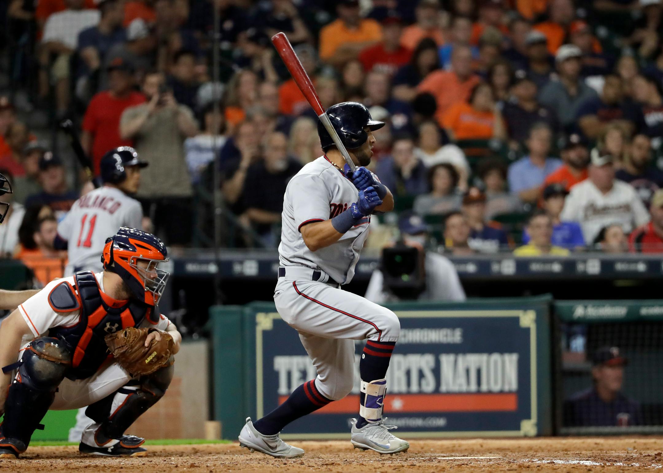 Minnesota Twins' Eddie Rosario, right, watches his single along with Houston Astros catcher Evan Gattis during the eighth inning of a baseball game Saturday, July 15, 2017, in Houston. (AP Photo/David J. Phillip)