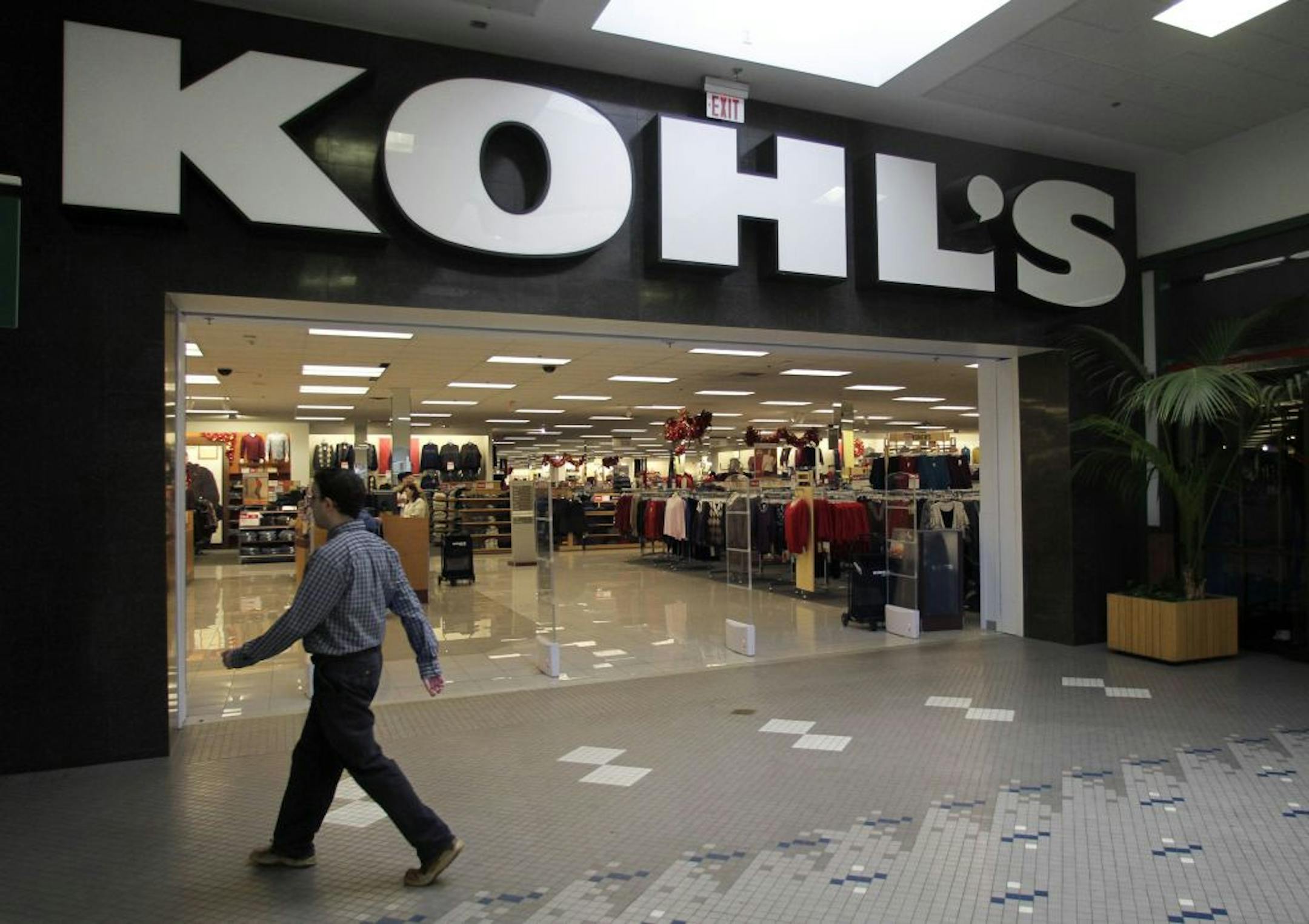In this Nov. 8, 2010 photo, a passer-by walks near the entrance of a Kohl's department store location, in Walpole, Mass. Kohl's Corp. said Wednesday, Nov. 11, it earned almost the same amount in this year's third quarter as last year's, even though its revenue rose, because its costs rose faster.