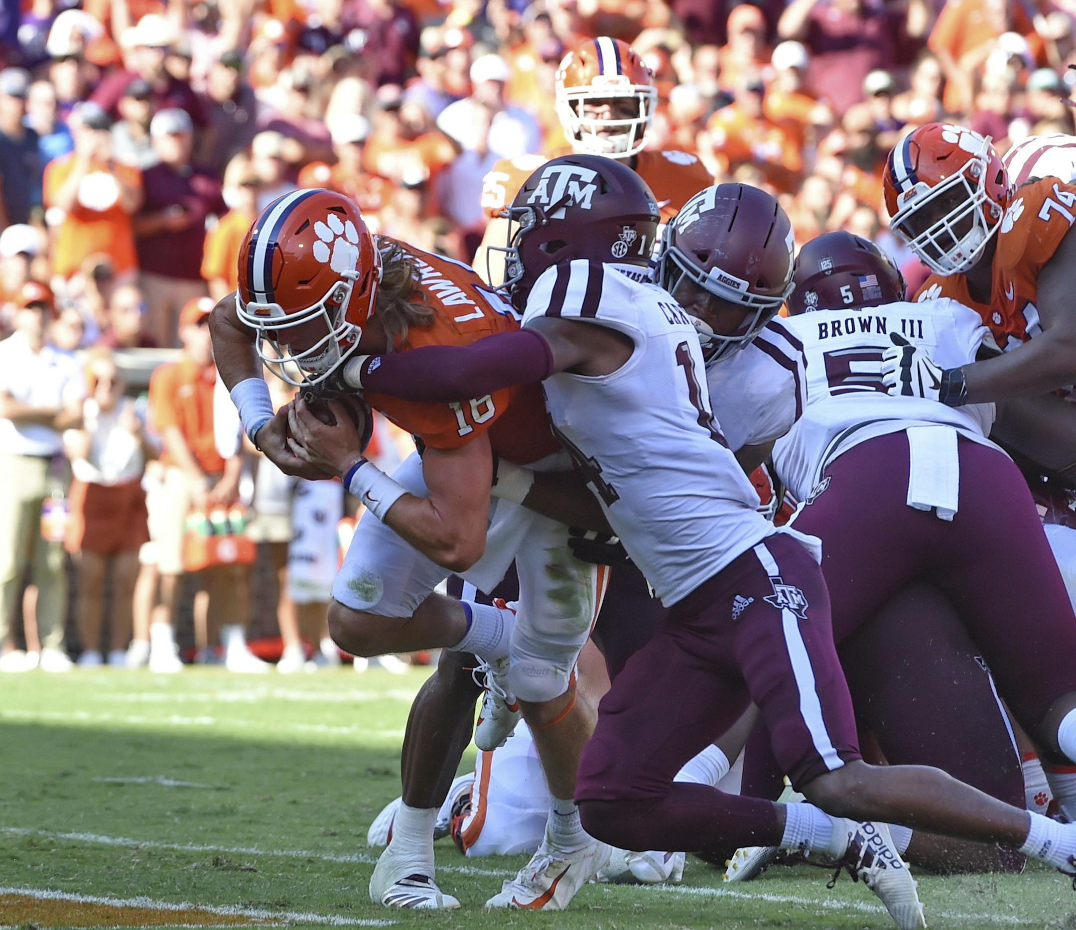 Clemson's Trevor Lawrence, left, scores a touchdown while being defended by Texas A&M's Keldrick Carper during the first half of an NCAA college football game Saturday, Sept. 7, 2019, in Clemson, S.C. (AP Photo/Richard Shiro)
