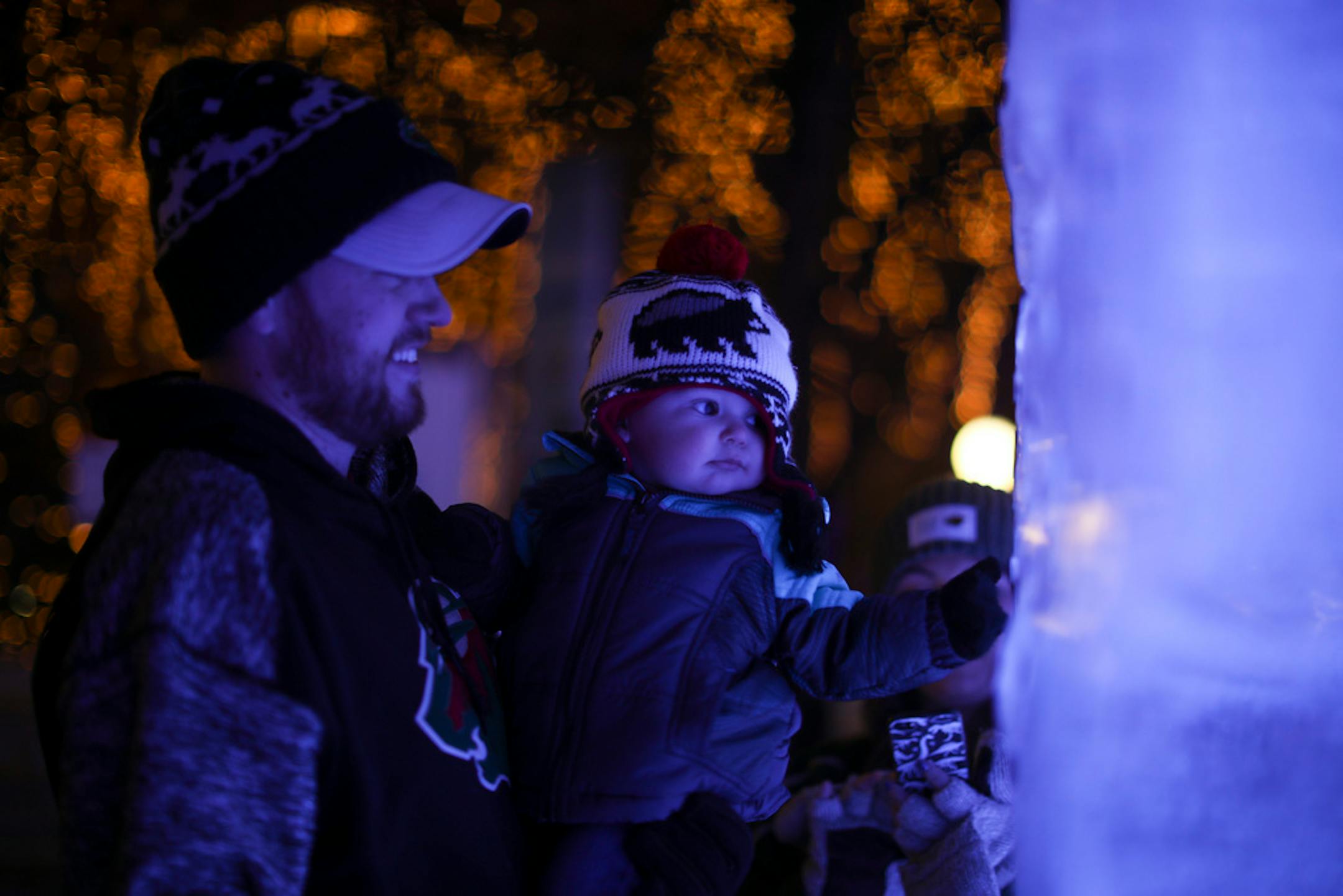 Dan Haroldson held his son, Coen, 10 months, so he could view the ice blocks close up at the St. Paul Winter Carnival in 2018 while his wife, Jordan Faust, photographed them.