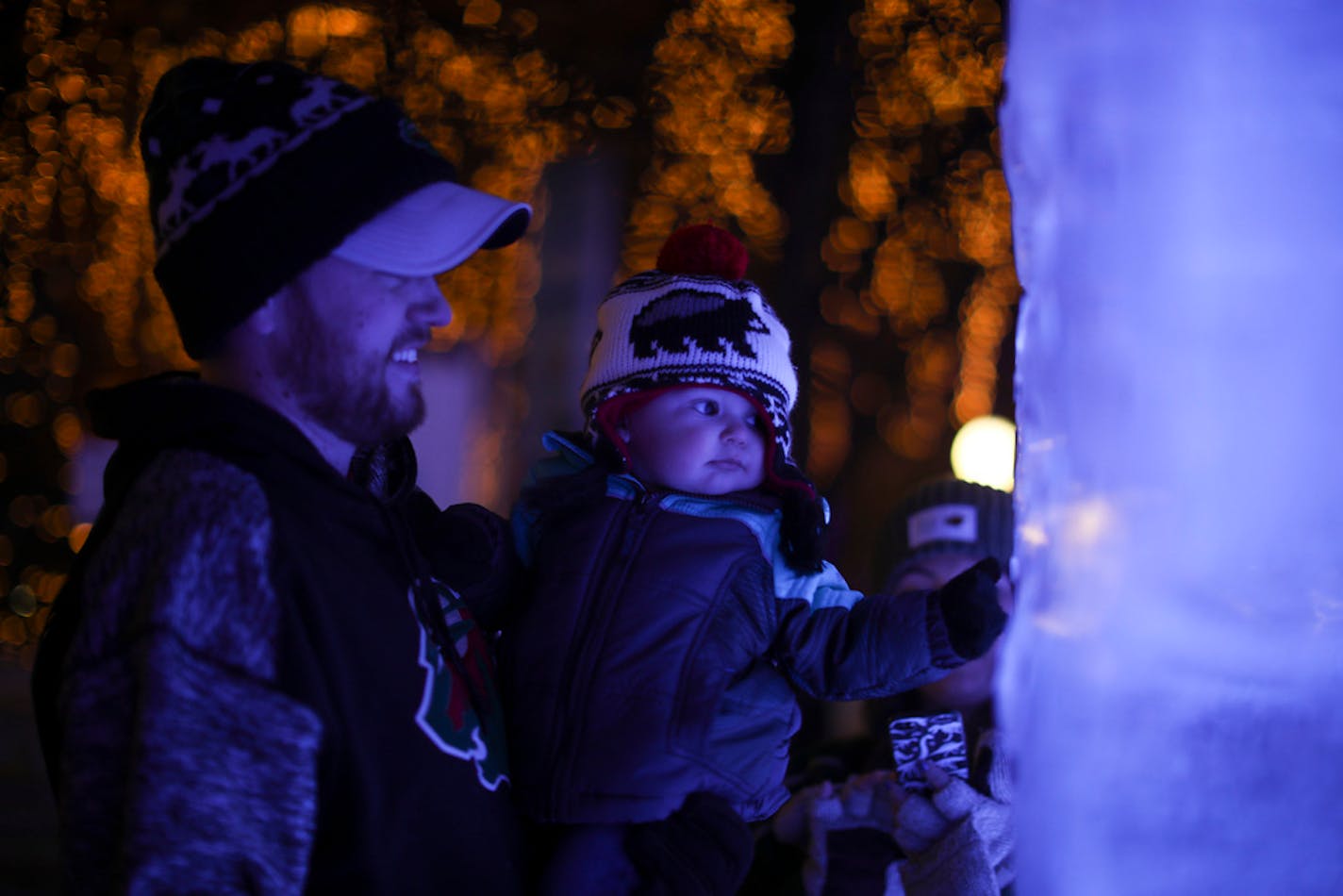 Dan Haroldson held his son, Coen, 10 months, so he could view the ice blocks close up at the St. Paul Winter Carnival in 2018 while his wife, Jordan Faust, photographed them.