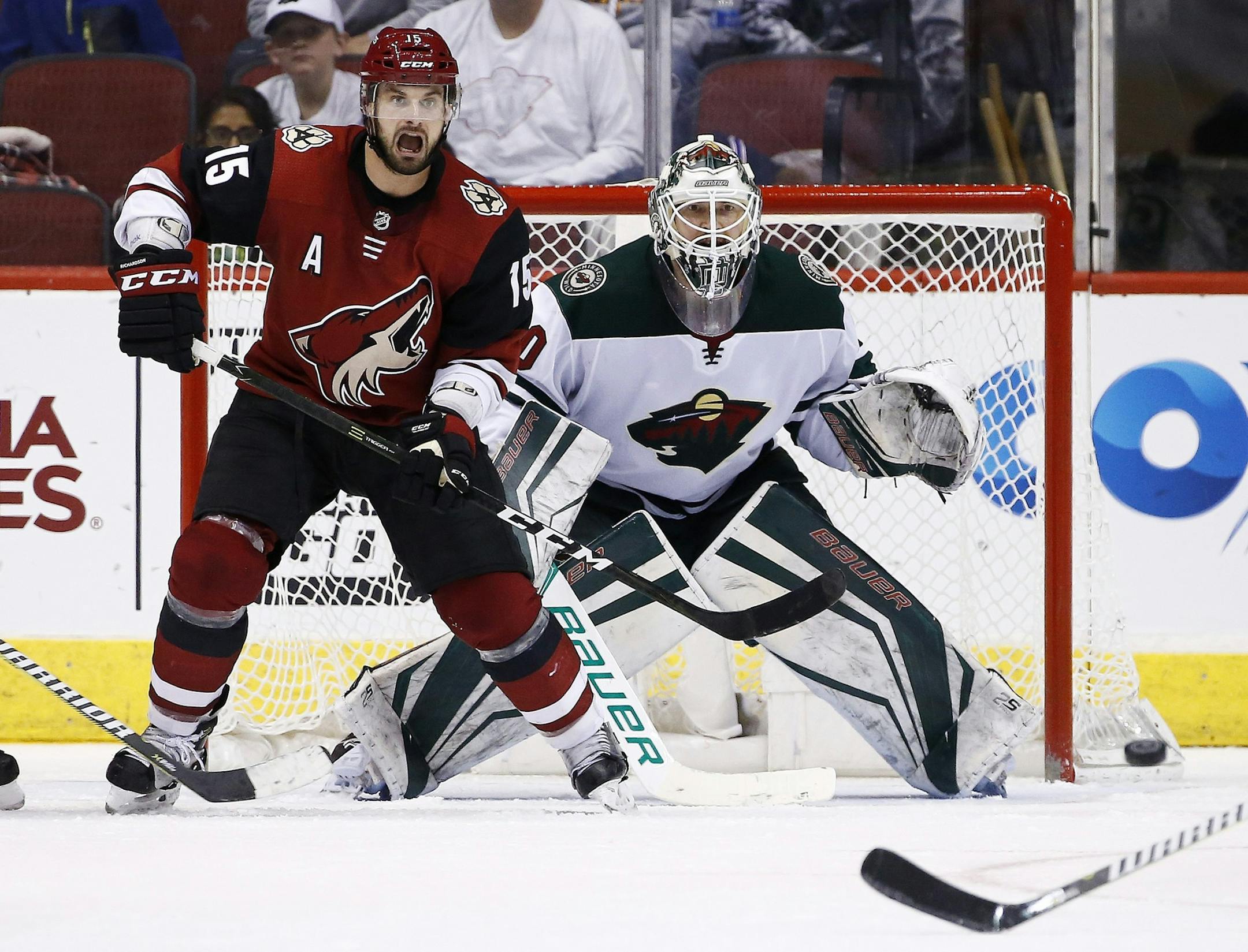 Arizona Coyotes center Brad Richardson (15) and Minnesota Wild goaltender Devan Dubnyk (40) watch the movement of the puck at them during the third period of an NHL hockey game Saturday, March 17, 2018, in Glendale, Ariz. The Wild defeated the Coyotes 3-1. (AP Photo/Ross D. Franklin)
