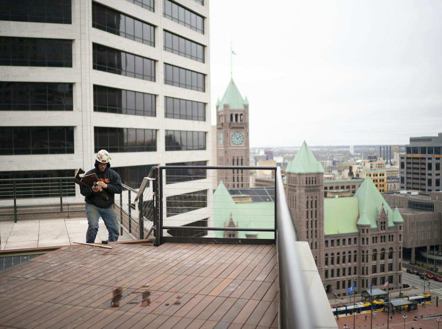 Construction workers worked on the 15th floor rooftop deck at the Capella Tower Wednesday. The downtown Minneapolis building was purchased last year by Shorenstein Properties of San Francisco.