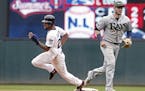 Minnesota Twins pinch runner Byron Buxton, left, races past Tampa Bay Rays second baseman Daniel Robertson as he heads to third on a throwing error by