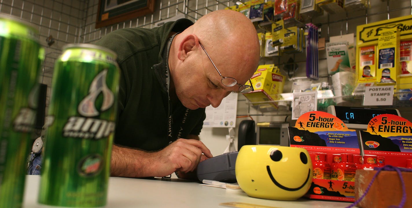 John Zitek, who is legally blind, checked a credit card in his small store in the state Human Services building. Zitek was recently told by the city of St. Paul to remove his popcorn machine, coffee maker and microwave; he has his own theory about what prompted the order.