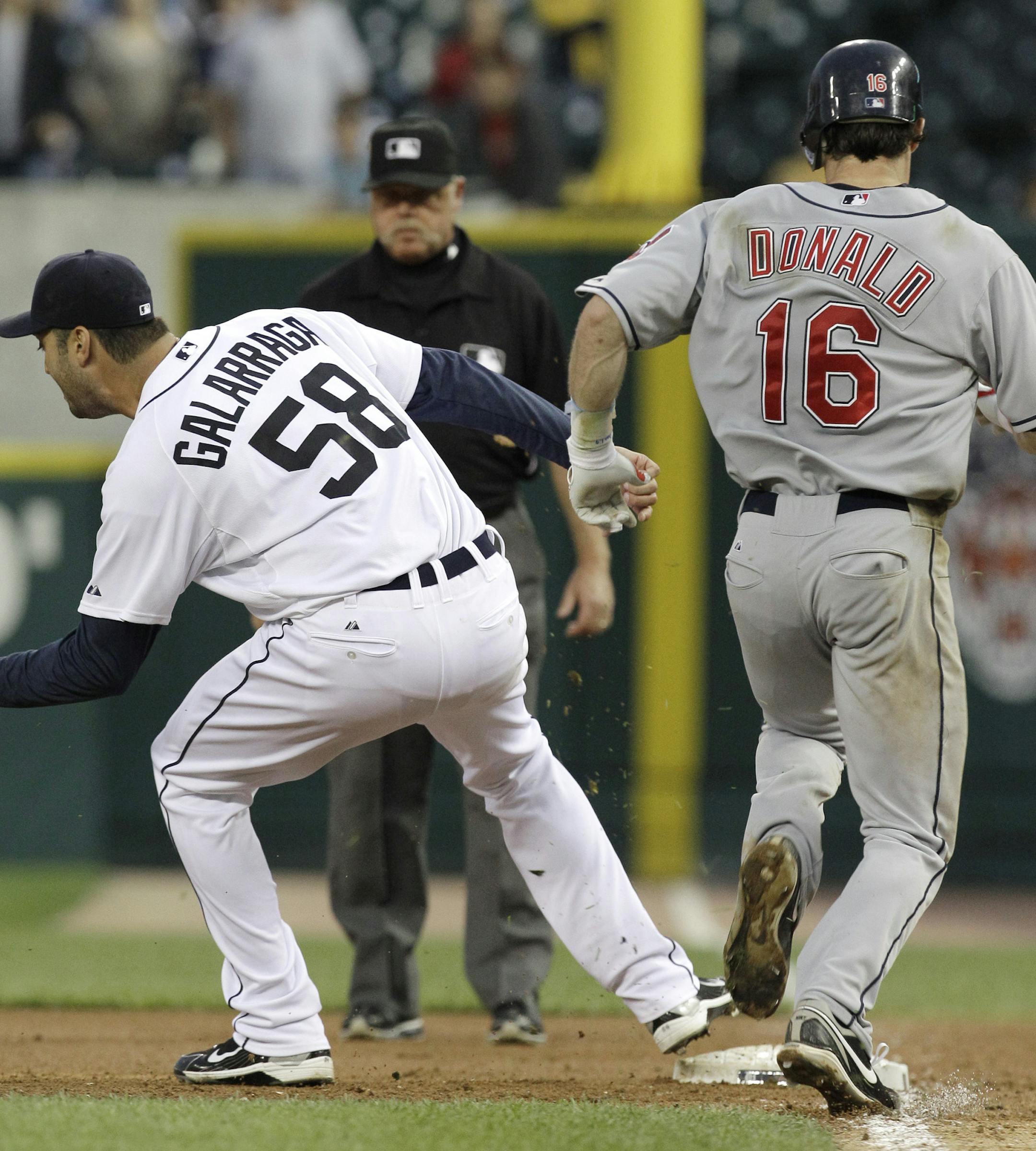 Detroit Tigers pitcher Armando Galarraga (58) covers first base as Cleveland Indians' Jason Donald, right, runs to the base and umpire Jim Joyce looks on in the ninth inning of a baseball game in Detroit Wednesday, June 2, 2010. Joyce called Donald safe and Galarraga lost his bid for a perfect game with two outs in the ninth inning on the disputed call at first base. Detroit won 3-0. (AP Photo/Paul Sancya) ORG XMIT: MIPS108