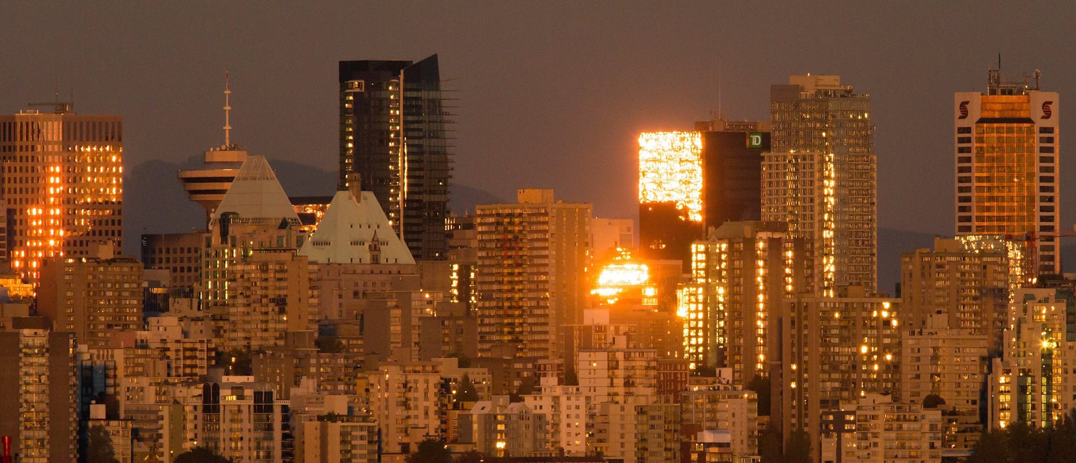 Boats travel on the waters of English Bay as the sun reflects off windows on buildings in downtown Vancouver, B.C., on Sunday, September 27, 2015. (Darryl Dyck/The Canadian Press via AP) ORG XMIT: CPOTK