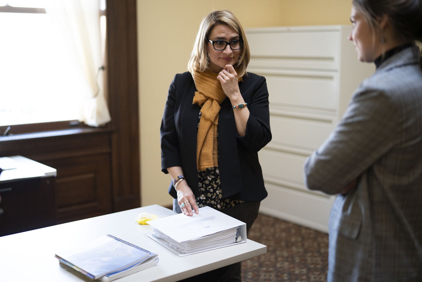 Lt. Gov.-Elect Peggy Flanagan talked with a communications director Kayla Castañeda while standing next the transition material from the governor's office in her temporary office at the State Capitol in St. Paul on Thursday.