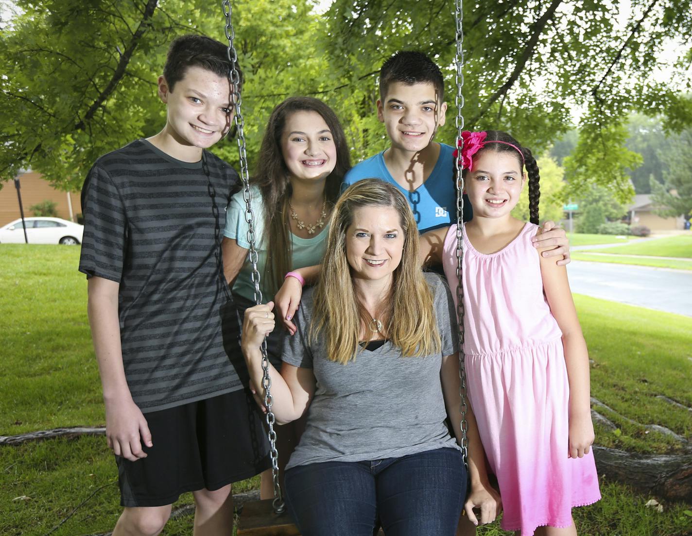 Melissa Sirek, surrounded by her four children; Joshua,15, Hannah, 12, Jacob, 15, and Sarah, 9, were photographed at their home on Tuesday, July 16, 2015, in Eden Prairie, Minn. Melissa was given an anonymous donation of gift cards from "12 Ordinary Women" one day last summer while she was hosting a garage sale at her house. Sirek is a single parent and three of her kids have autism.