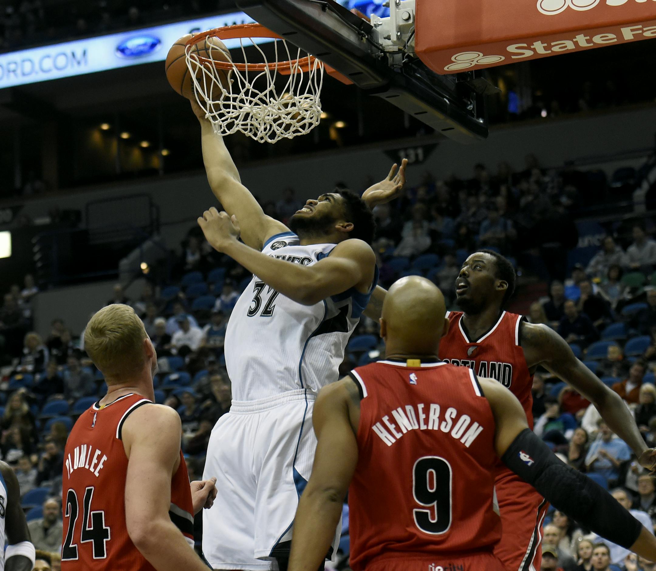 Minnesota Timberwolves center Karl-Anthony Towns (32) shoots over Portland Trail Blazers center Mason Plumlee (24), guard Gerald Henderson (9) and forward Al-Farouq Aminu as Timberwolves forward Kevin Garnett (21) watches during the second quarter of an NBA basketball game on Saturday, Dec. 5, 2015, in Minneapolis. (AP Photo/Hannah Foslien)