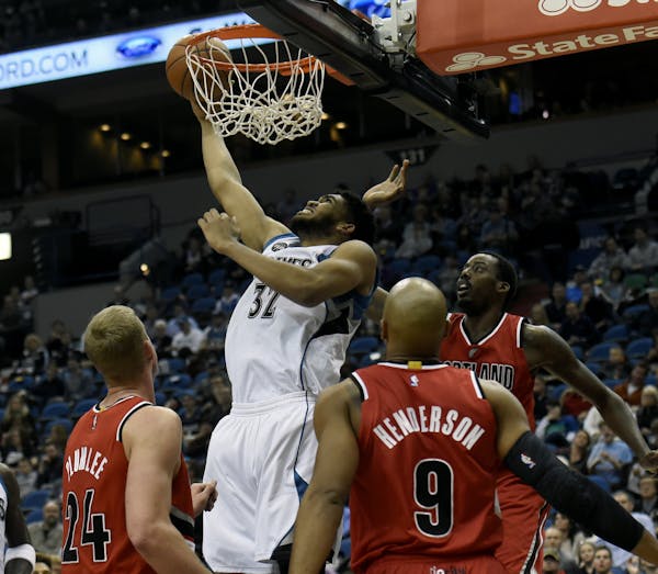 Minnesota Timberwolves center Karl-Anthony Towns (32) shoots over Portland Trail Blazers center Mason Plumlee (24), guard Gerald Henderson (9) and for