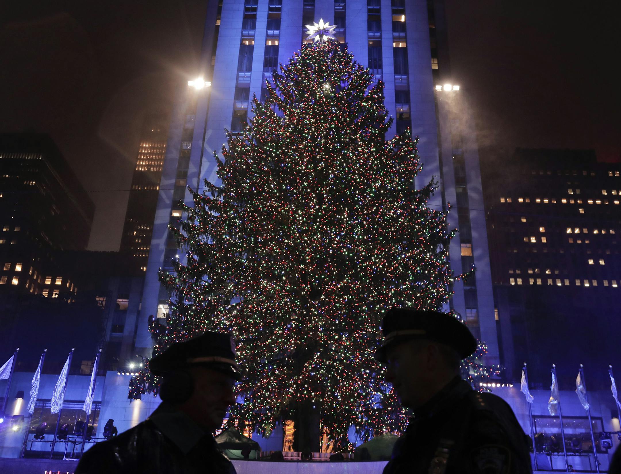 New York police officers stand across from the Rockefeller Center Christmas tree after the 84th annual Rockefeller Center Christmas tree lighting ceremony, Wednesday, Nov. 30, 2016, in New York.