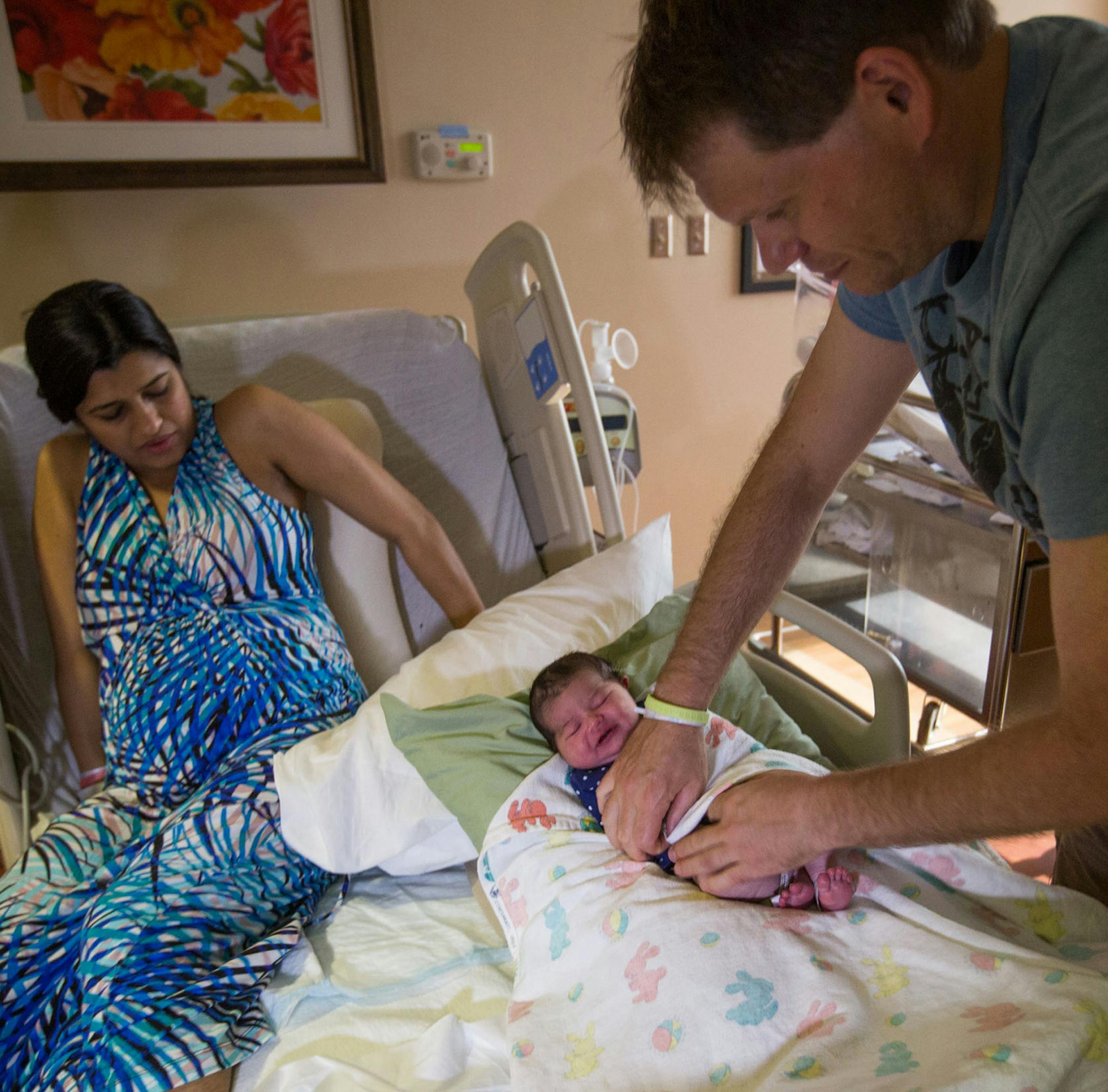 Mandeep Virk-Baker, left, seen Sept. 5, 2014 in Rockville, Maryland at Shady Grove Adventist Hospital with husband Sam Baker and three-day-old daughter Hera, says she would not have been able to start breast feeding without the hospital's baby-friendly practices. Illustrates BREASTFEEDING (category a), by Brigid Schulte (c) 2014, The Washington Post. Moved Wednesday, Sept. 10, 2014. (MUST CREDIT: Photo for The Washington Post by Evelyn Hockstein)