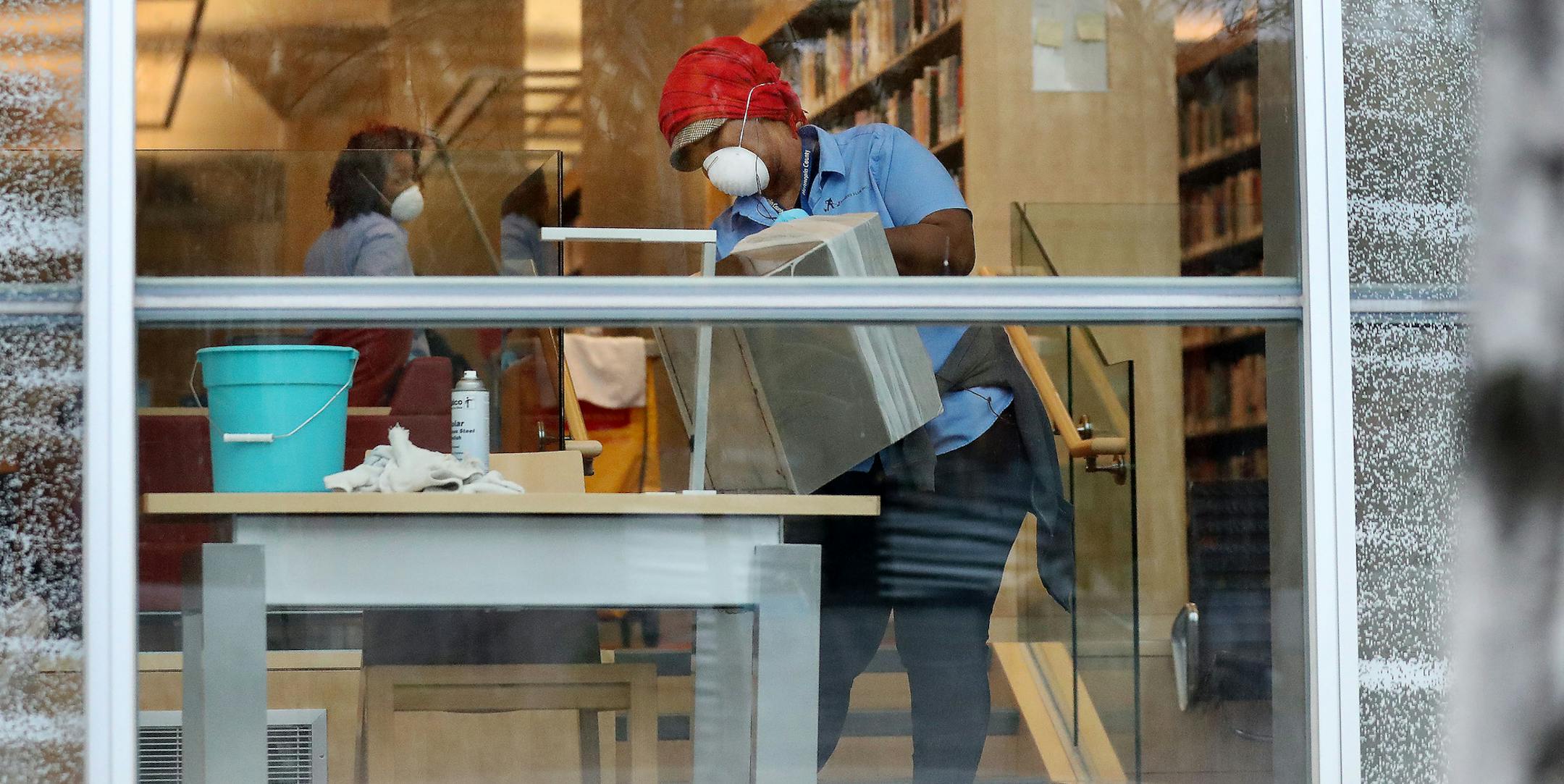 Workers sanitize furniture at Minneapolis Central Library in downtown in March.