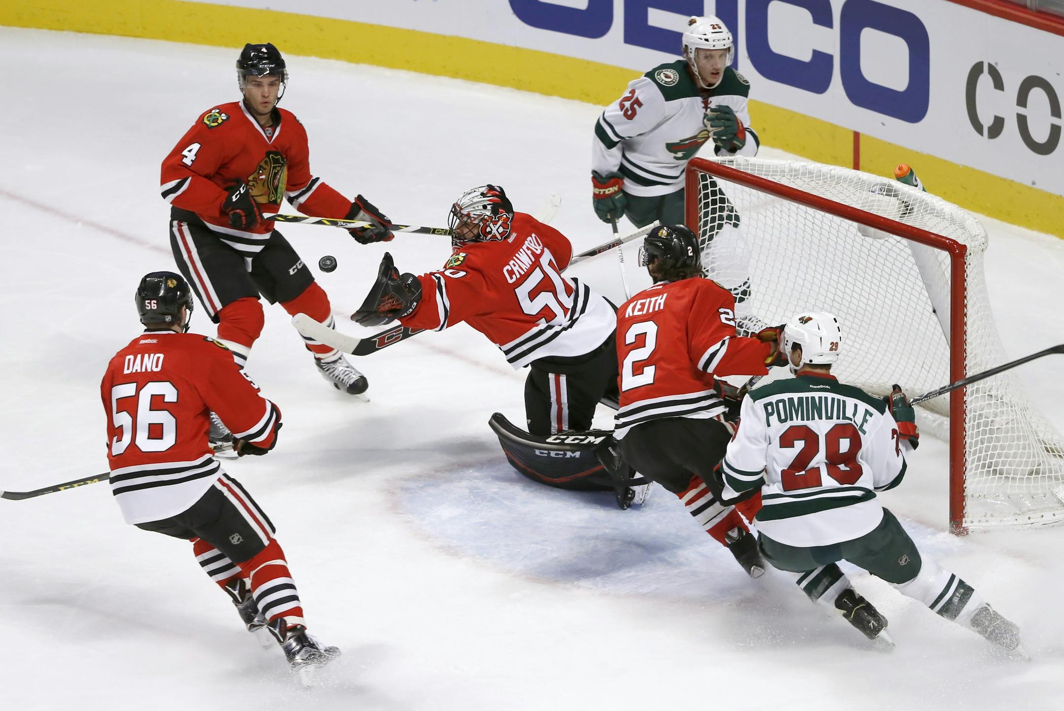 Chicago Blackhawks goalie Corey Crawford stretches to make a save during the first period of an NHL hockey game against the Minnesota Wild, Tuesday, Dec. 1, 2015, in Chicago. Watching the play are Marko Dano (56) Niklas Hjalmarsson (4) Duncan Keith (2) Jason Pominville (29) and Jonas Brodin (25). (AP Photo/Charles Rex Arbogast)