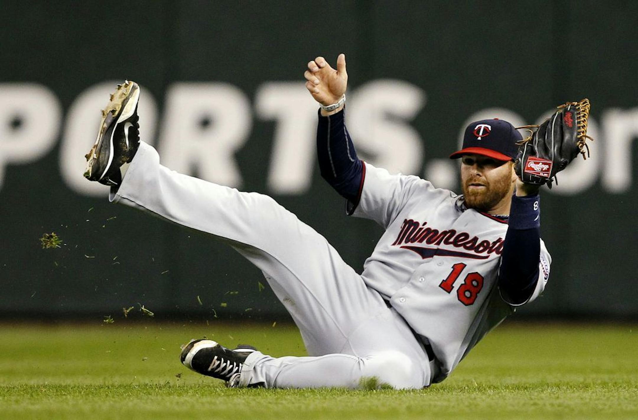 Minnesota Twins right fielder Ryan Doumit skids after catching a fly ball from Seattle Mariners' Dustin Ackley in the fourth inning of a baseball game, Friday, May 4, 2012, in Seattle.