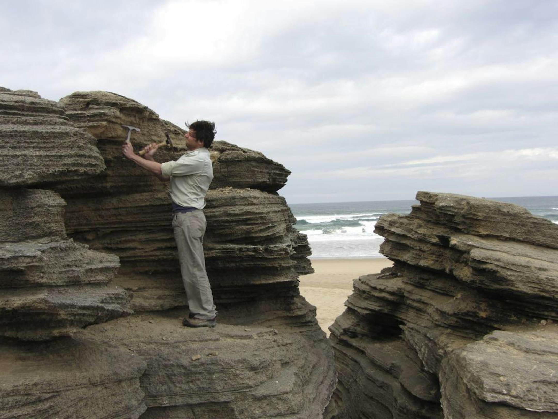 Dr. Michael O'Leary, of Curtin University in Australia, part of a research team studying past sea level changes, examines a rock formation that preserved ancient beaches and dunes on the coast of South Africa, June 23, 2012. In a bid to better project the expected rise in sea level from global warming, the team is studying a past era, the Pliocene, that appears to have experienced a sharp rise, too.