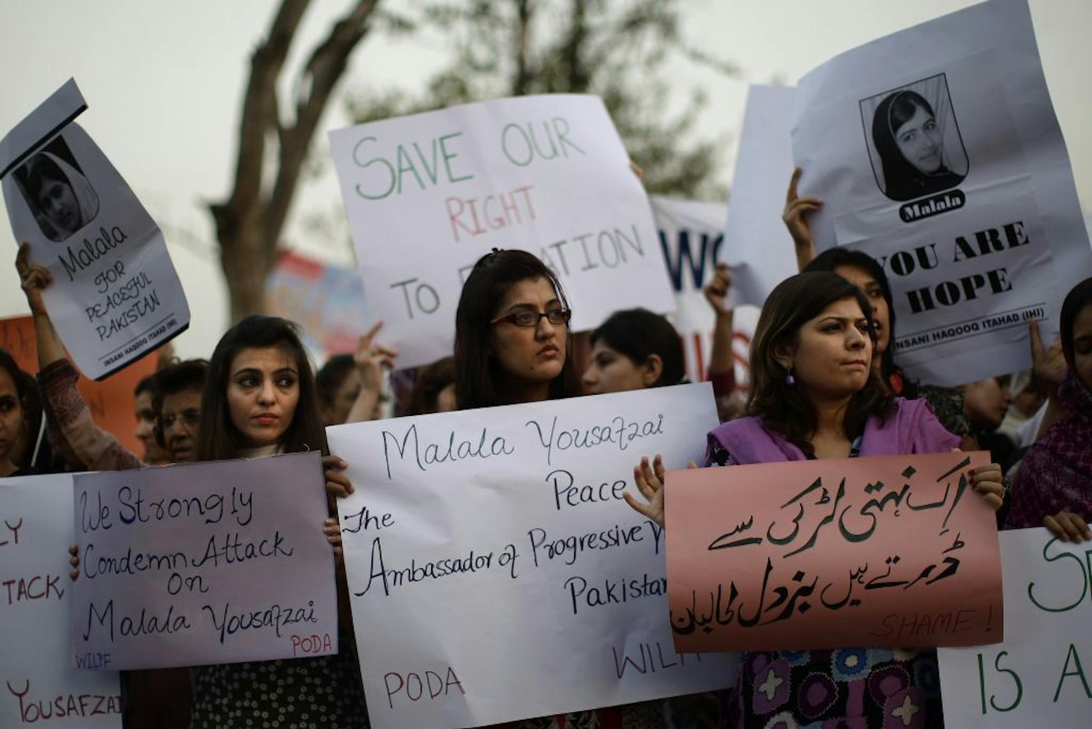 Pakistani women, hold banners during a protest condemning the attack on schoolgirl Malala Yousufzai, in Islamabad, Pakistan, Wednesday, Oct. 10, 2012. Pakistani doctors successfully removed a bullet Wednesday from the neck of a 14-year-old girl who was shot by the Taliban for speaking out in support of education for women, a government minister said. Banner bottom right reads, " The Taliban is afraid of an unarmed girl."
