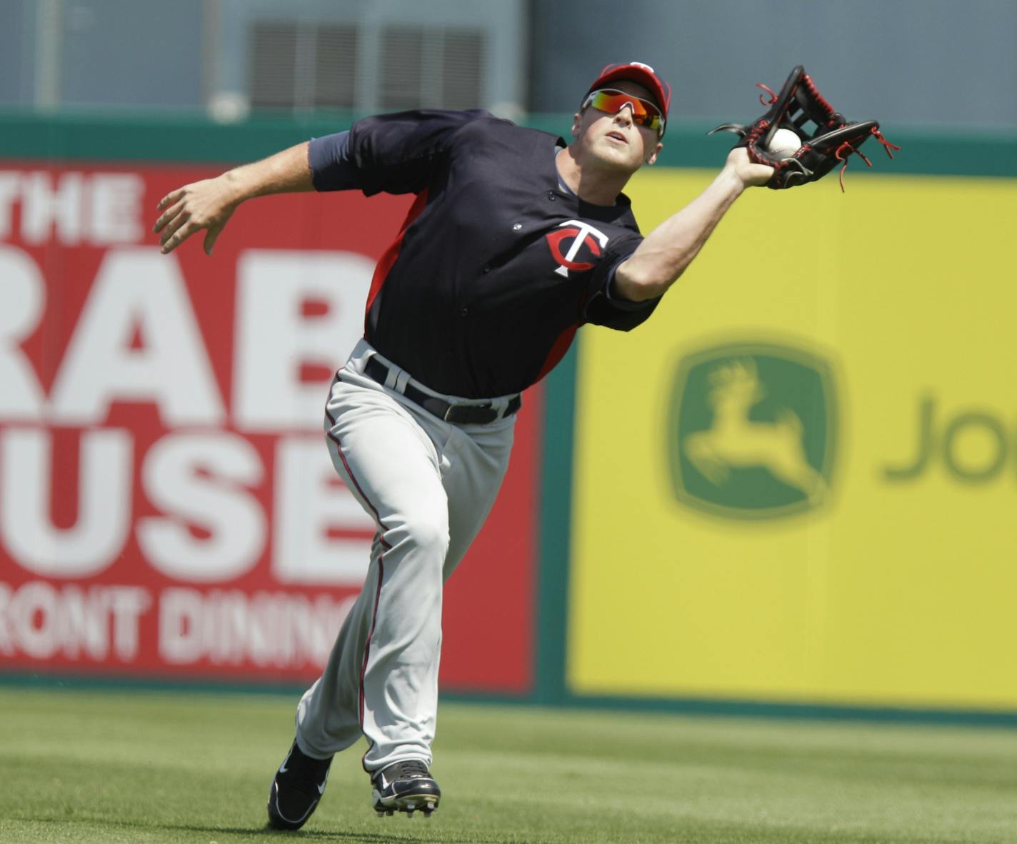 Minnesota Twins right fielder Brian Dinkelman chases down the fly out by Florida Marlins' Omar Infante during the sixth inning of a spring training baseball game, Tuesday, March 22, 2011, in Jupiter, Fla.