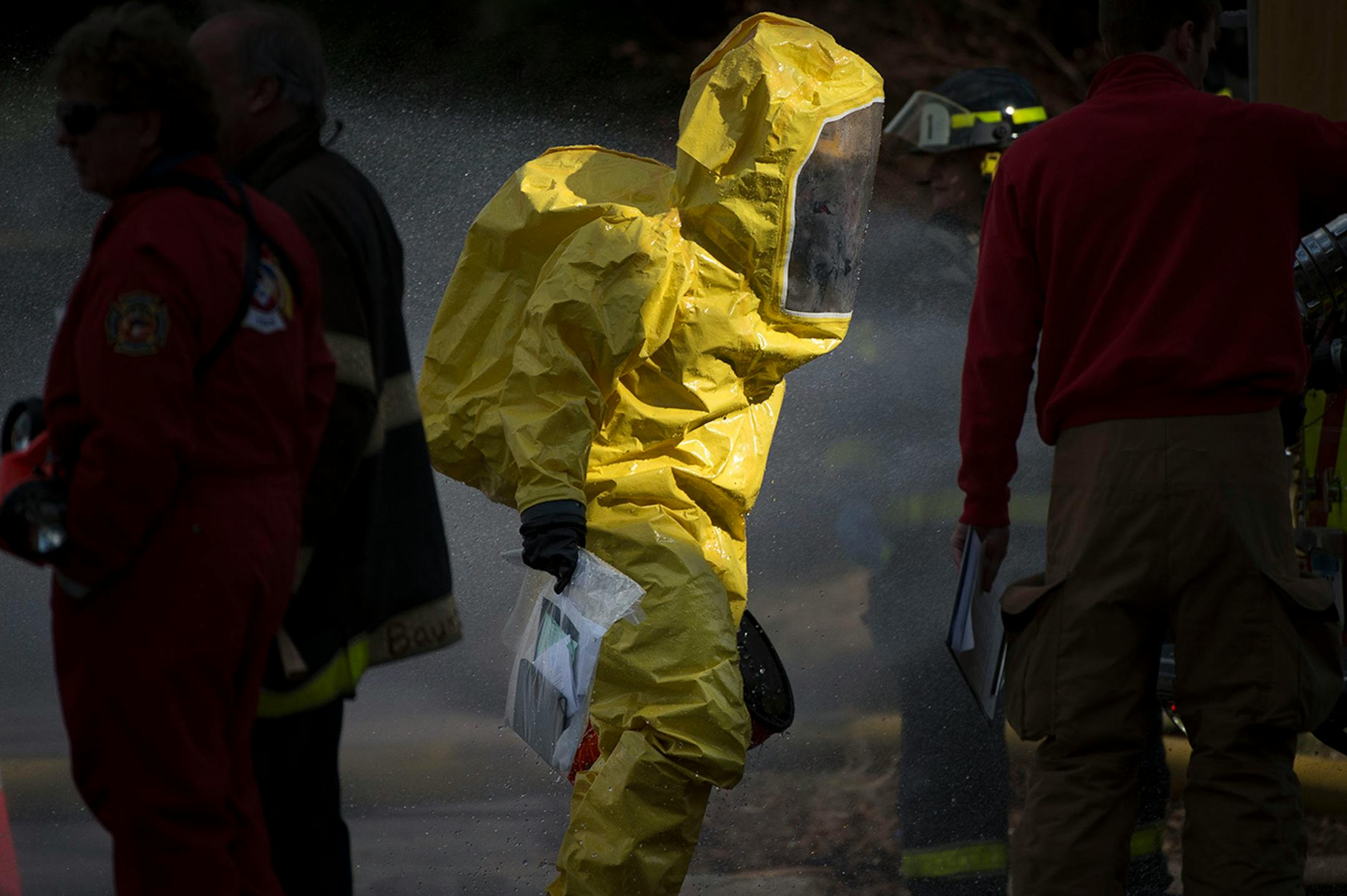 A hazardous material worker carries plastic bag with books and papers that were taken from a residence in the Marcy Holmes neighborhood of Minneapolis on the 500 block of 6th Street Southeast on Friday, April 10, 2015.