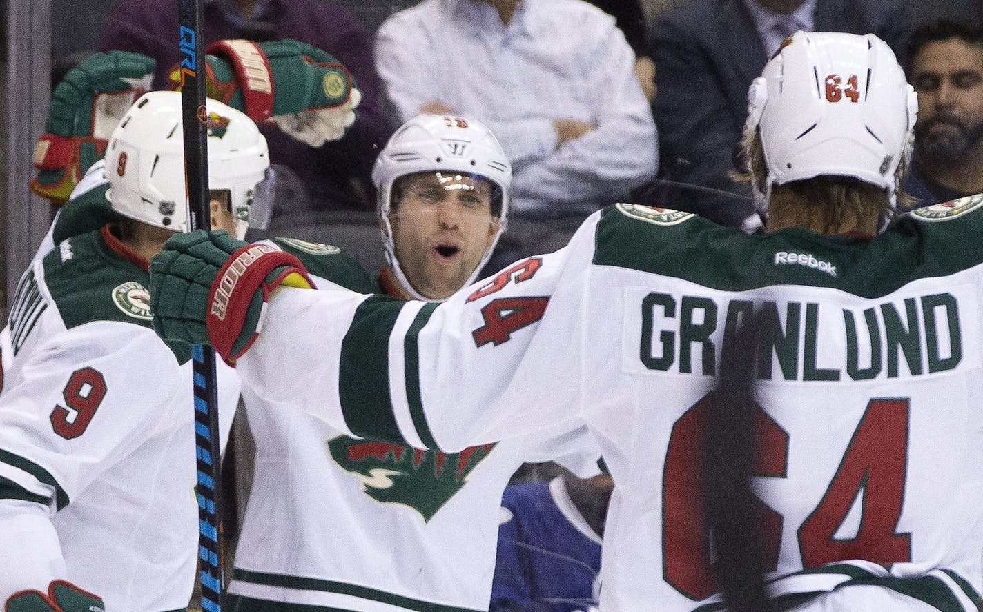 Minnesota Wild left wing Jason Zucker, center, celebrates his goal against the Toronto Maple Leafs with teammates Mikko Koivu, left, and Mikael Granlund during the first period of NHL hockey game in Toronto on Wednesday, Dec. 7, 2016. (Chris Young/The Canadian Press via AP)