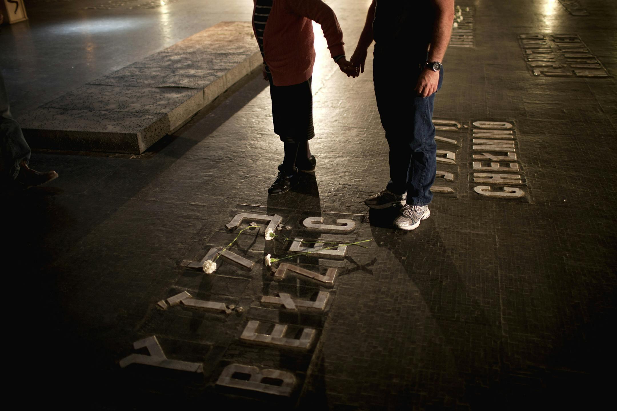 Relatives of Holocaust victims lay flowers next to the names of concentration camps during a ceremony marking the annual Holocaust Remembrance Day at the Yad Vashem Holocaust Memorial in Jerusalem, Monday, April 8, 2013. Israel came to a standstill for two mournful minutes Monday as sirens pierced the air in an annual ritual to remember the 6 million Jews systematically murdered by German Nazis and their collaborators during the Holocaust in World War II. (AP Photo/Oded Balilty)