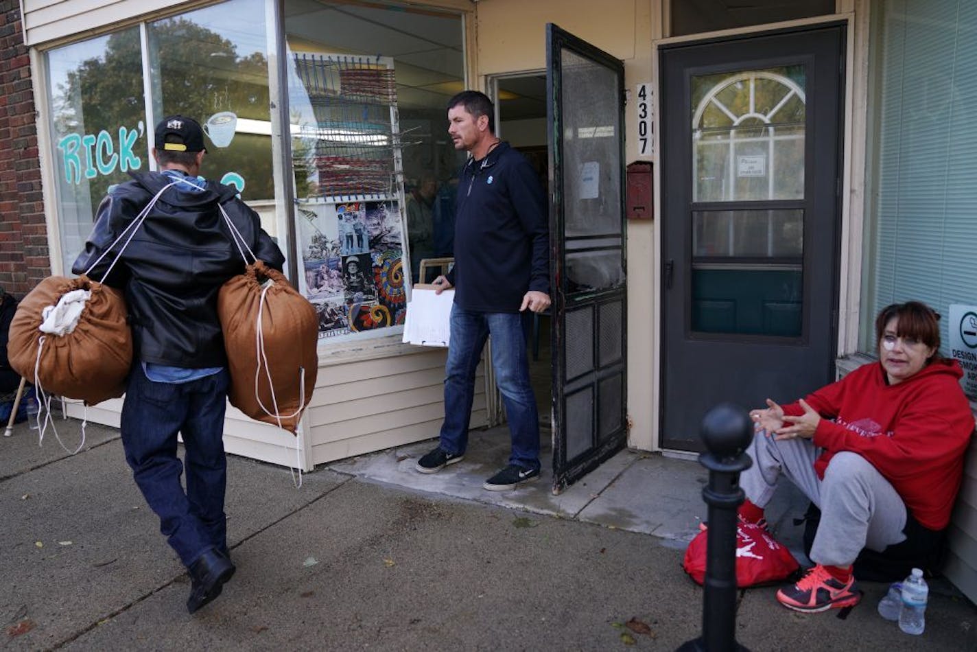 Tom McKenna talked with Army veteran Larry Svien, left, outside his organization Every Third Saturday as he and other veterans waited to get tickets to shopping for free supplies at McKenna's attached store.