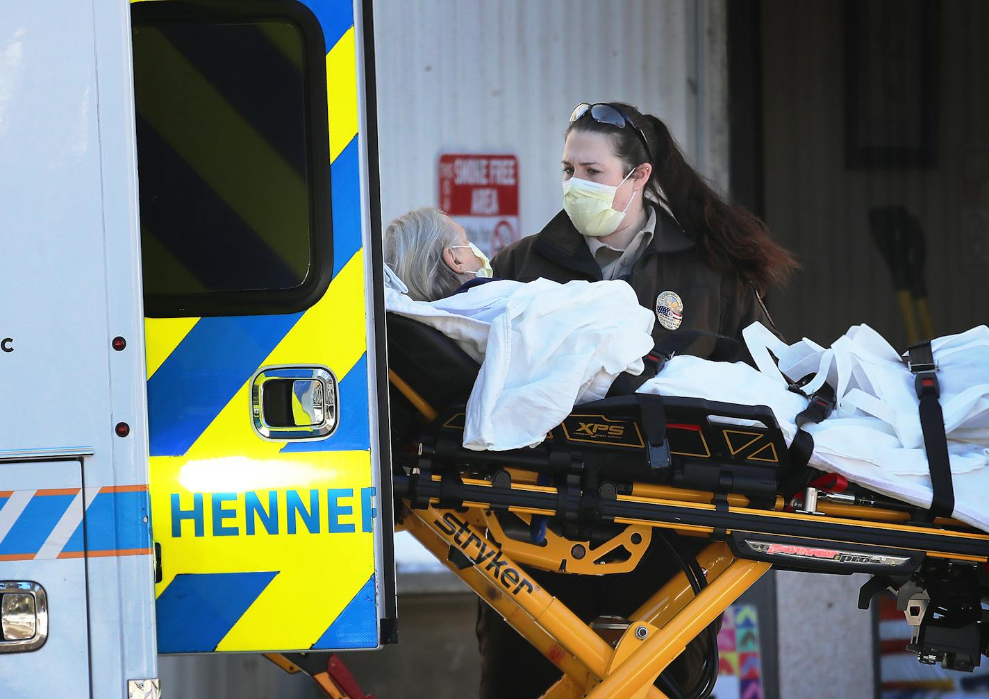 HCMC paramedics transport a person from Augustana Apartments who was having difficulty breathing to a nearby ambulance Nov. 13, 2020, in Minneapolis.