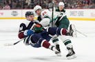 Minnesota Wild left wing Kevin Fiala, back, knocks over Colorado Avalanche center Nathan MacKinnon during the third period of an NHL hockey game Satur