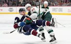Minnesota Wild left wing Kevin Fiala, back, knocks over Colorado Avalanche center Nathan MacKinnon during the third period of an NHL hockey game Satur