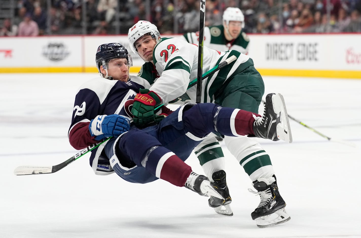 Minnesota Wild left wing Kevin Fiala, back, knocks over Colorado Avalanche center Nathan MacKinnon during the third period of an NHL hockey game Saturday, Oct. 30, 2021, in Denver. The Avalanche won 4-1. (AP Photo/David Zalubowski)