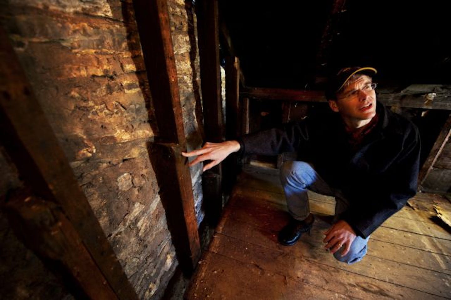 Tom Schroeder shows an old roof line of a wooden structure that was attached to, and predated, the stone house.