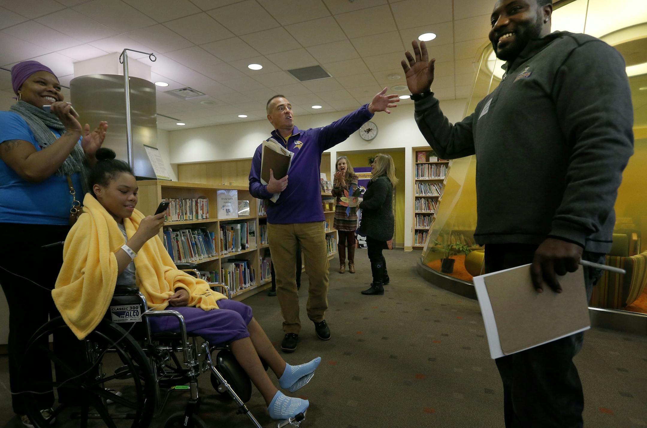 Minnesota Vikings director of community relations Brad Madson introduced former and present players including Tyrone Carter to patients and families at the University of Minnesota Masonic Children's Hospital on Tuesday. ] CARLOS GONZALEZ cgonzalez@startribune.com - November 25, 2014, Minneapolis, Minn., Minnesota Vikings, Brad Madson, the Vikings director of community relations, Viking John Sullivan will host an early Thanksgiving for young patients and their families--roughly 100 people--at the