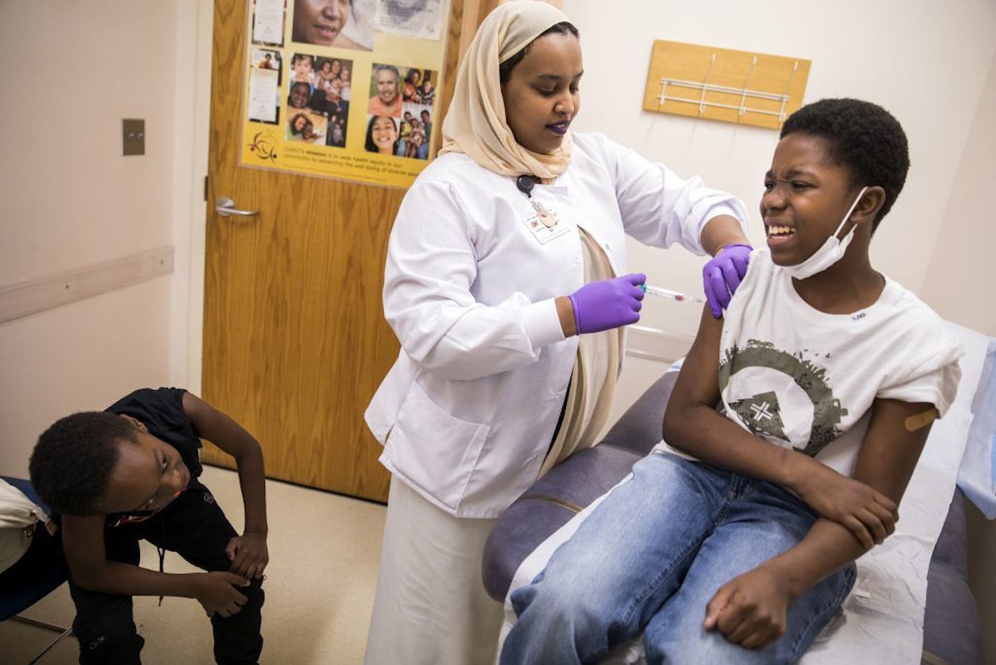 Medical assistant Fathia Salah, center, administered shots to patient Arthur Price, Jr., right, 11, as his brother Nehemiah Little, 8, left, looked on. Unless Congress acts, three key health care programs will lose funding, including $27 million that Minnesota clinics use to care for the uninsured.